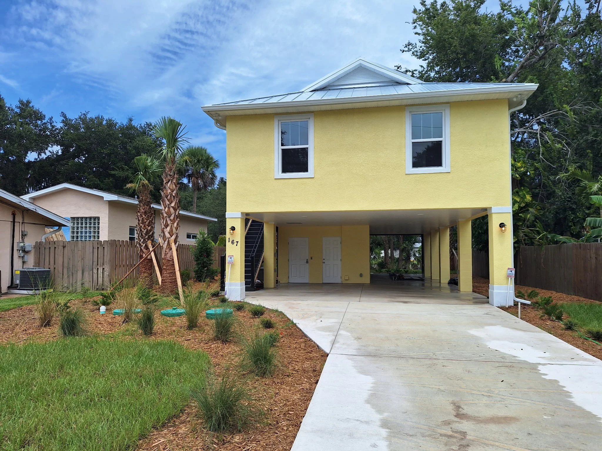 This wide front view captures the completed exterior painting project, showcasing coastal colors, clean lines, and a durable finish designed for waterfront conditions.