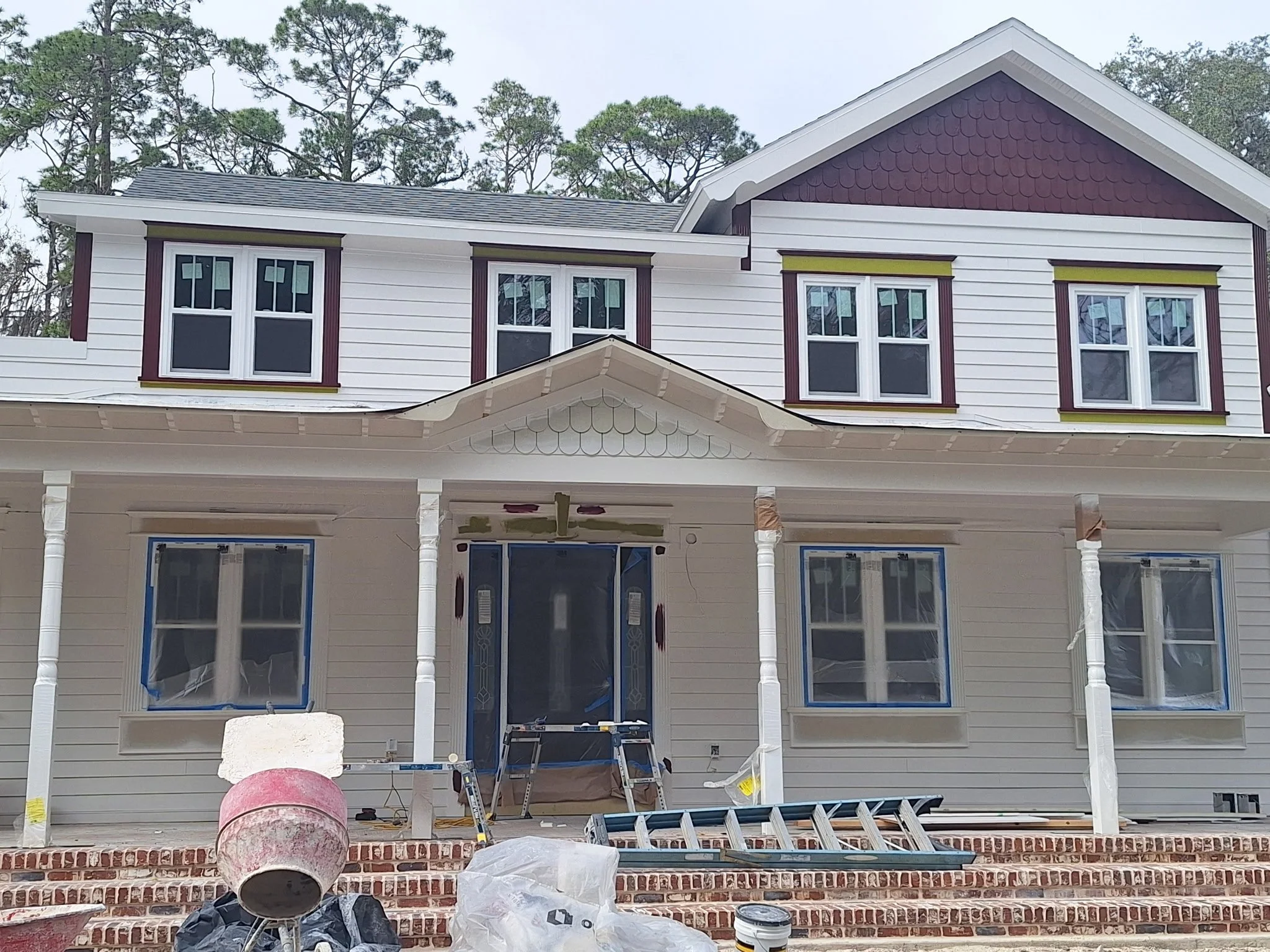 Exterior house painting project in Orlando, FL showing professional prep work, masked windows, trim painting, and detailed craftsmanship in progress.