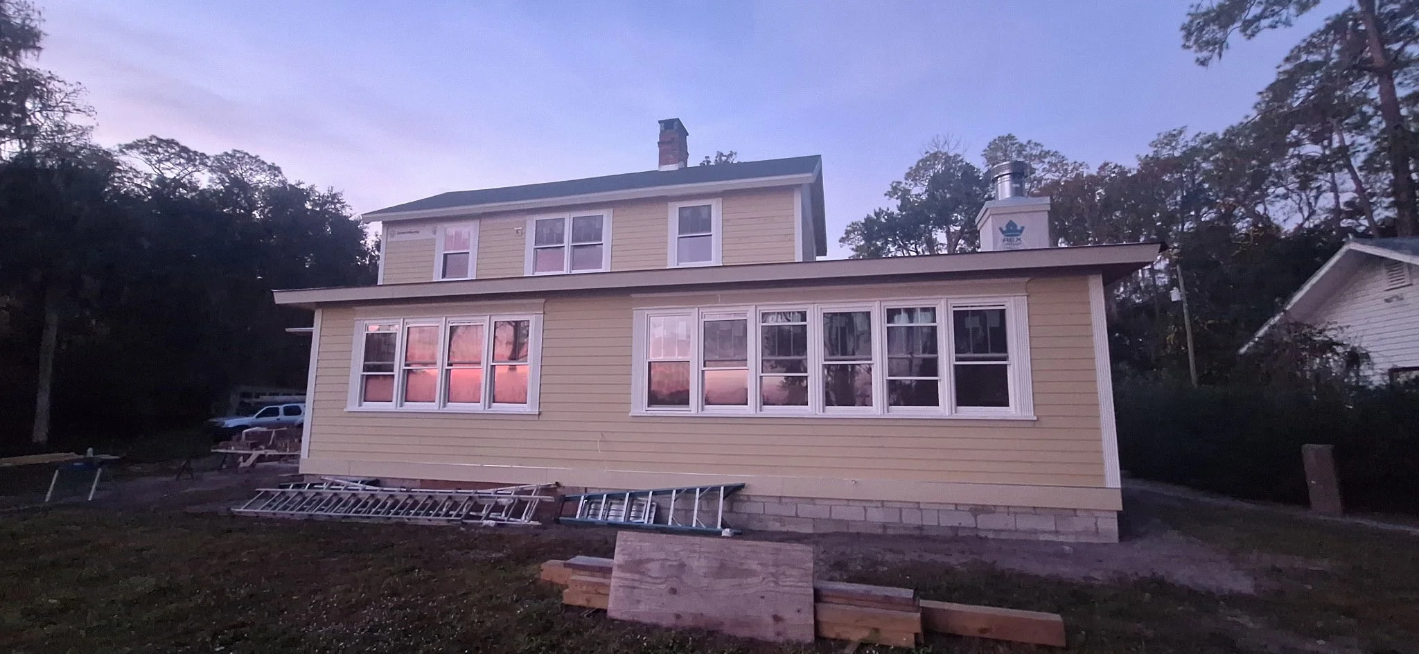 This side exterior view of a Pierson, FL home showcases Hardie board siding during an active exterior painting project. Proper surface preparation, trim detailing, and professional application techniques are used to ensure even coverage and long-term
