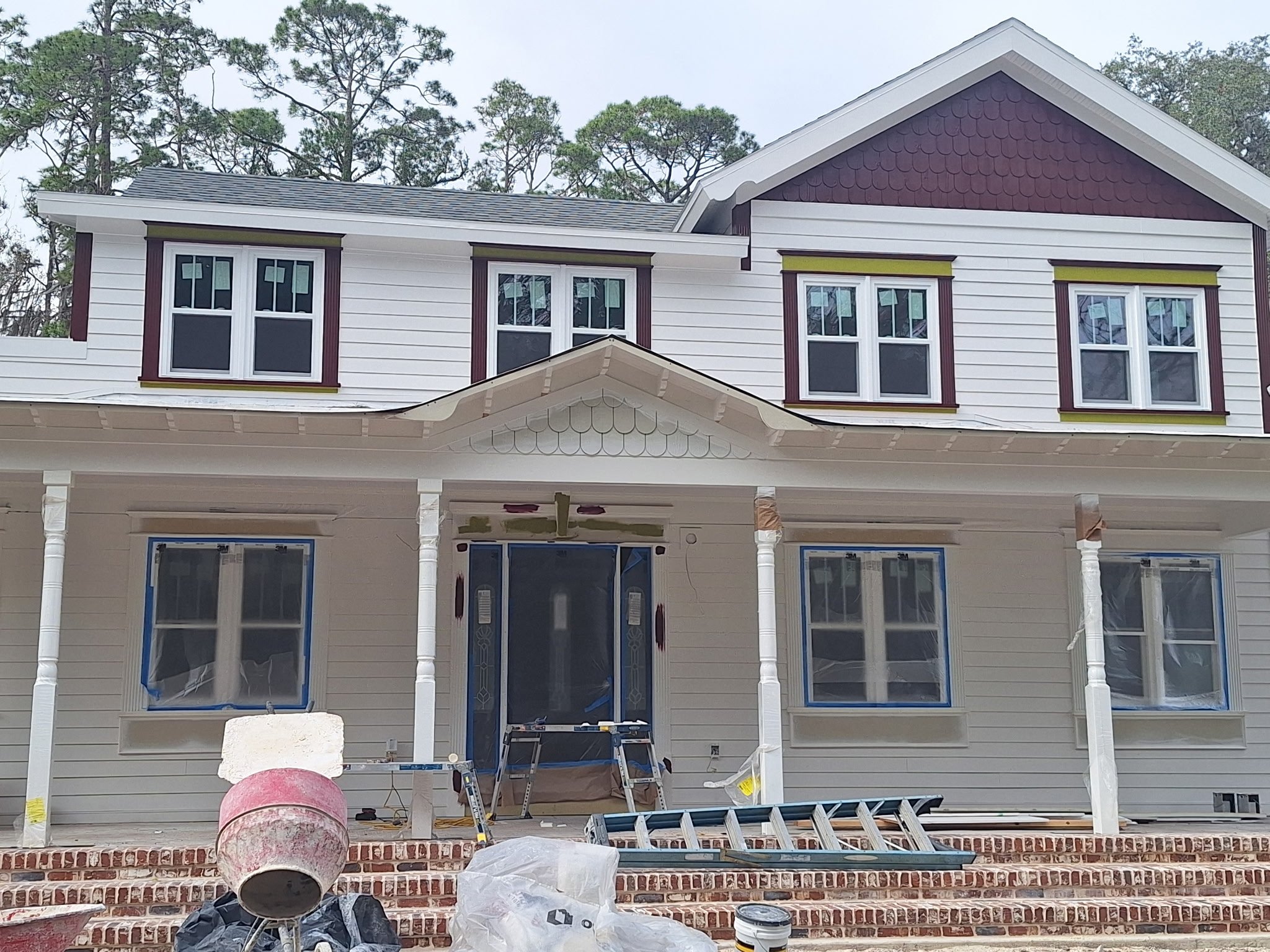 Current exterior house painting project in Orlando, FL featuring detailed prep, masked windows, trim work, and professional workmanship by Coats of Quality Painting.