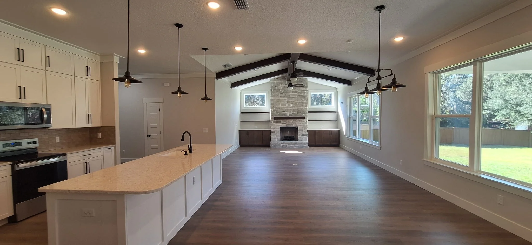 Kitchen & Living Room Open Concept
This open-concept kitchen and living room in Sanford, Florida received a complete professional interior paint finish. The soft, warm wall color enhances the natural light while complementing the dark ceiling beams, 