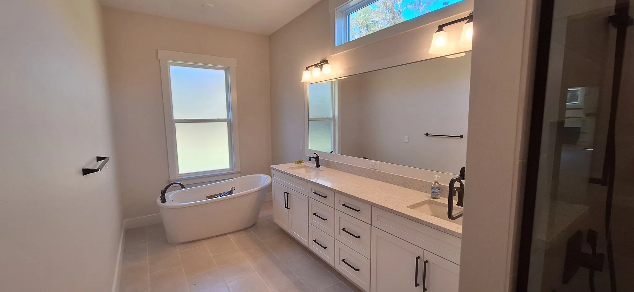 This new construction bathroom shows off a beautifully finished interior paint job with soft, modern tones that blend seamlessly with the stone-look tiles and sleek black hardware. Coats of Quality Painting completed the entire interior prep, priming