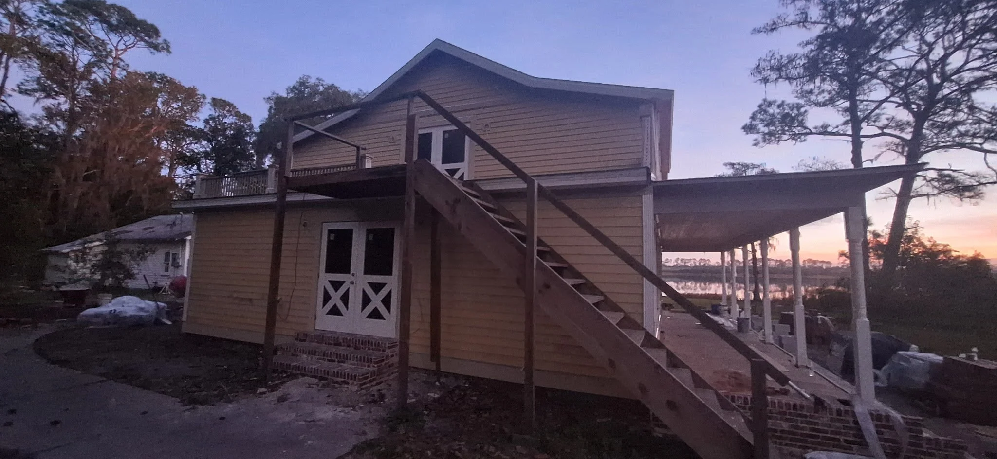 This rear exterior painting project in Pierson, FL captures the ongoing preparation and painting of Hardie board siding and trim areas. Our team ensures all surfaces are properly prepped and protected before applying high-quality exterior paint formu