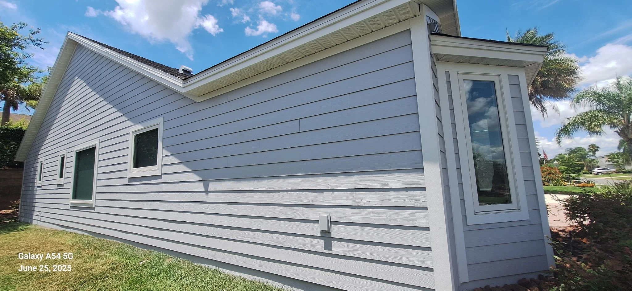 Hardie Board siding freshly painted light gray with white trim in Volusia County, Florida — exterior house painting by Coats of Quality Painting
