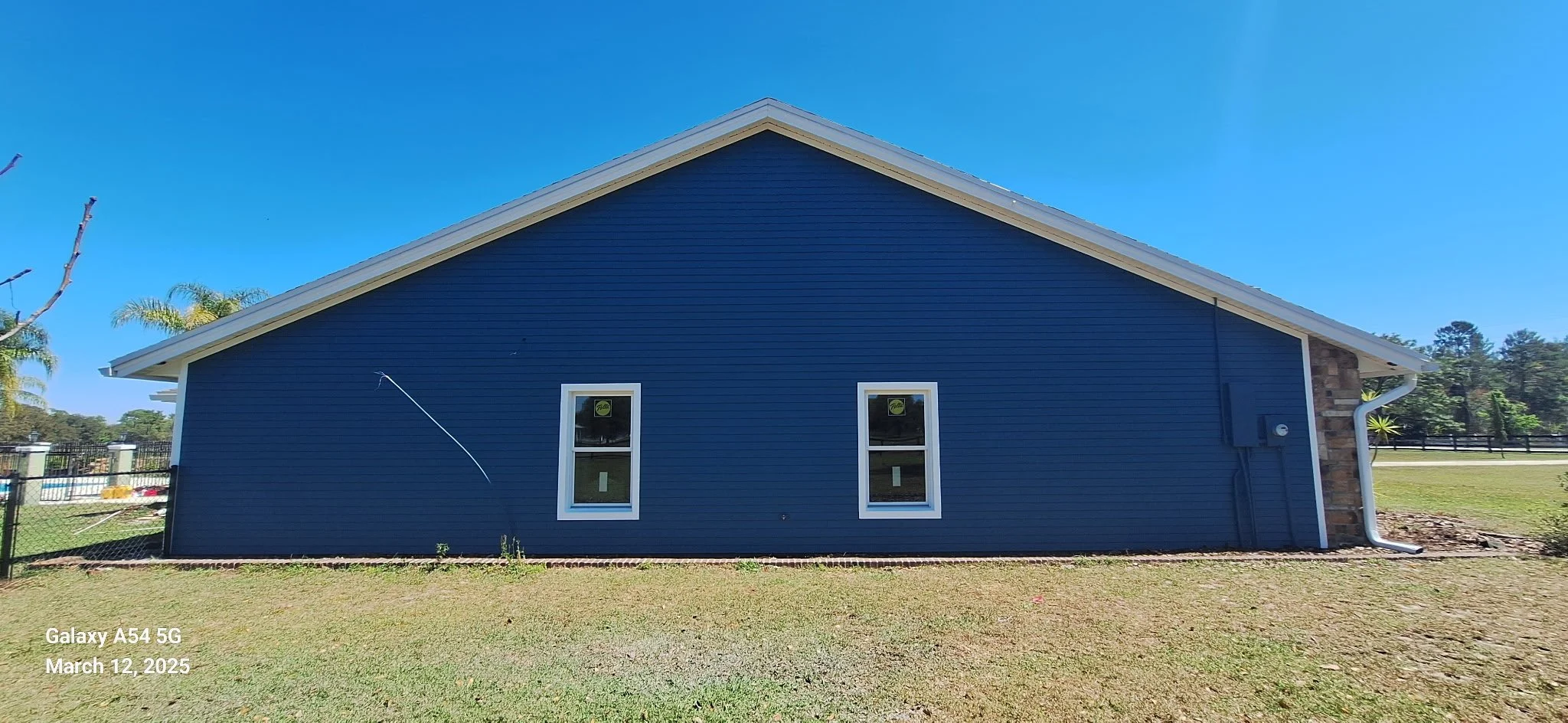 Side view of a freshly painted Ocala Florida home with deep blue siding and white trim