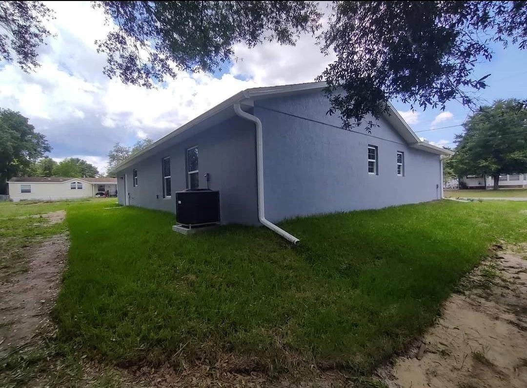 Side view of freshly painted gray exterior home in DeLand Florida with white trim and modern finish