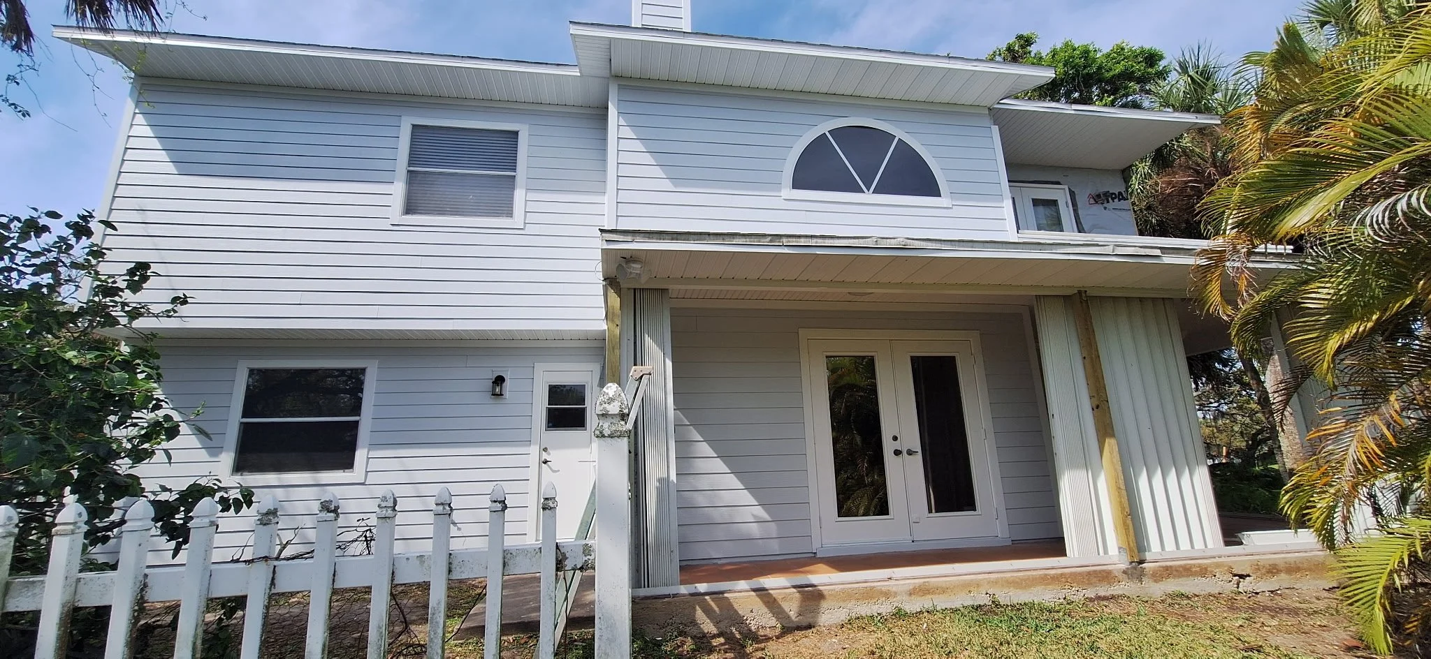 Back exterior of white modern home in Melbourne Florida after repaint.