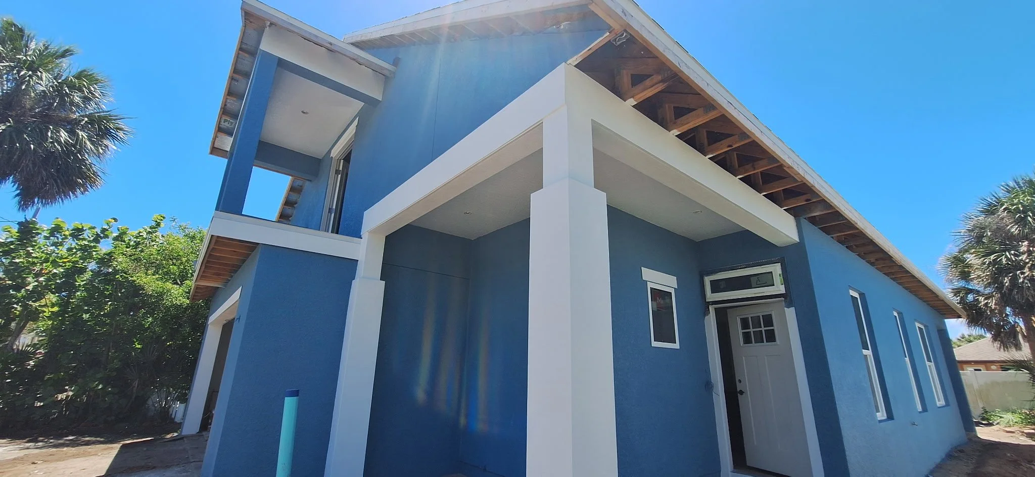 Side entry walkway of blue coastal home with white trim New Smyrna Beach