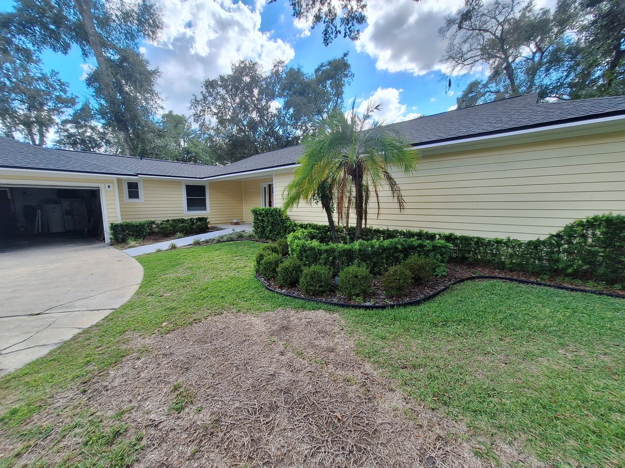Modern sunny yellow exterior home in Longwood FL with white trim and lush Florida landscaping