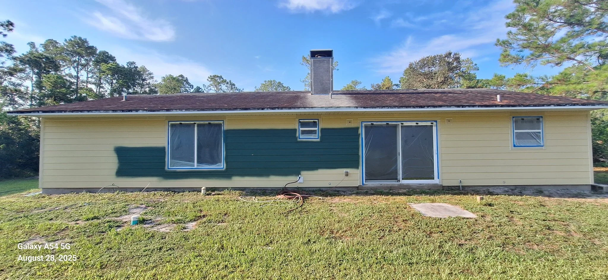 This side elevation highlights an exterior painting project in progress in New Smyrna Beach. The image shows careful preparation and paint application designed to protect the home from sun exposure, moisture, and seasonal weather changes.