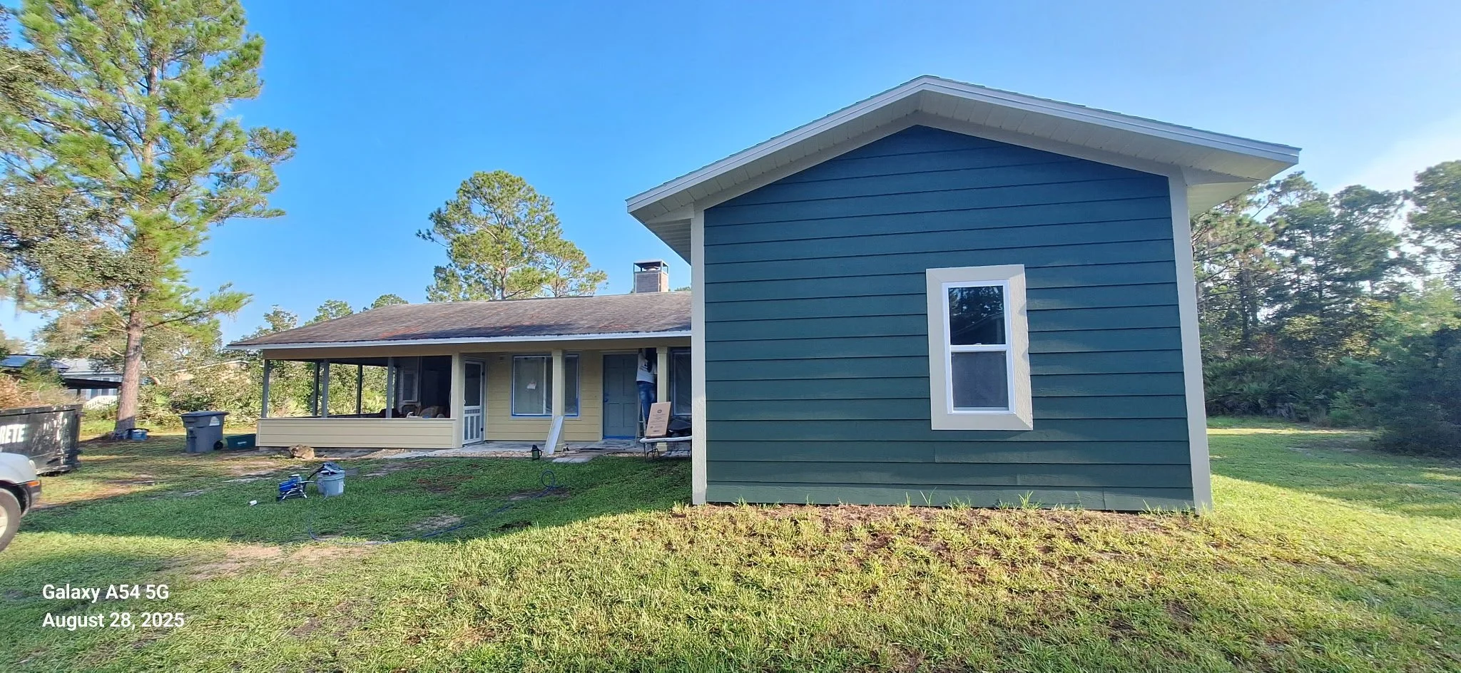 Rear view of a completed exterior house painting project in New Smyrna Beach, FL. The green Hardie board siding provides a fresh, modern look while offering long-lasting protection against Florida’s coastal climate.
