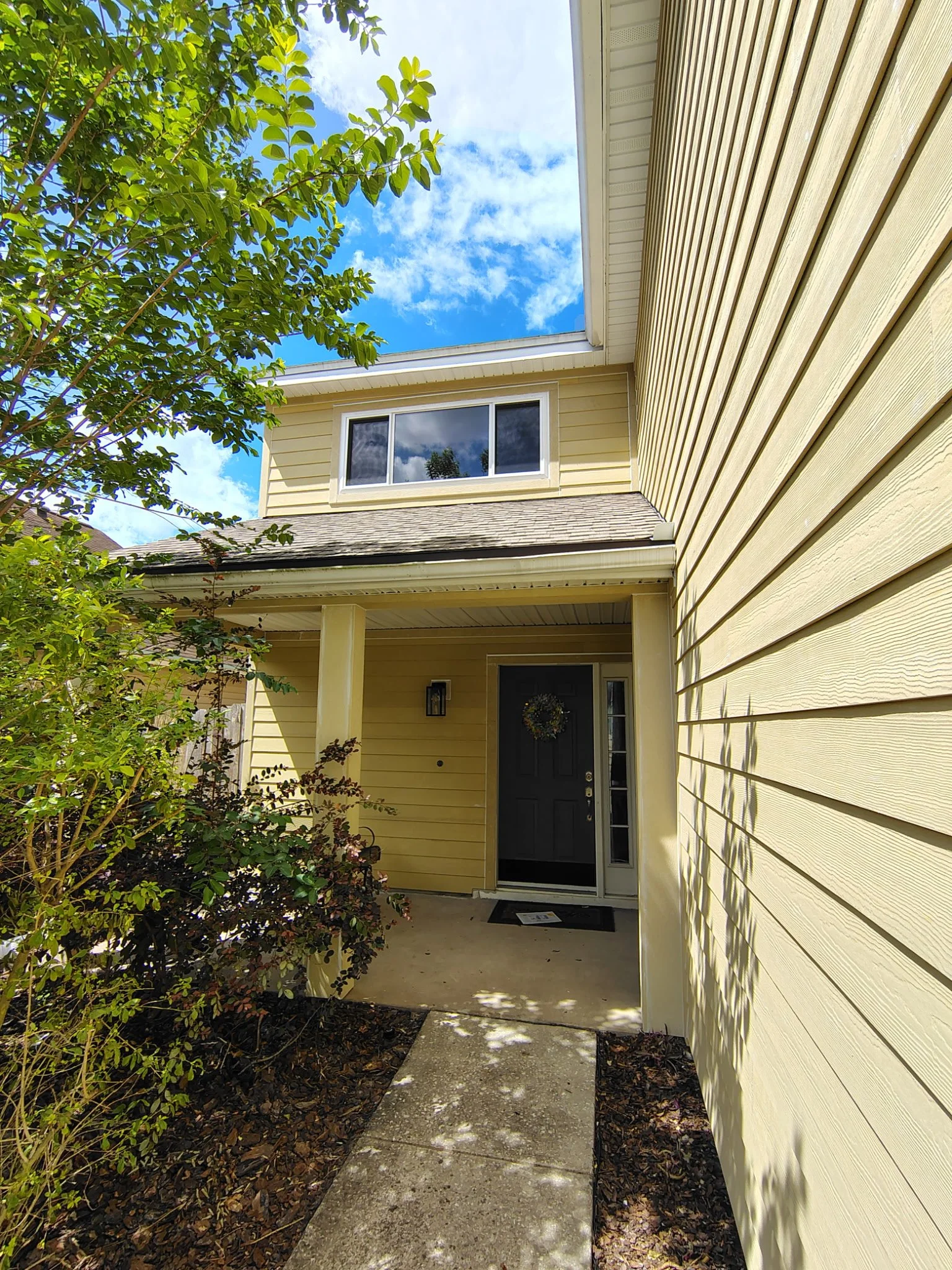 Front entry of Longwood FL home before exterior painting showing trim and siding condition