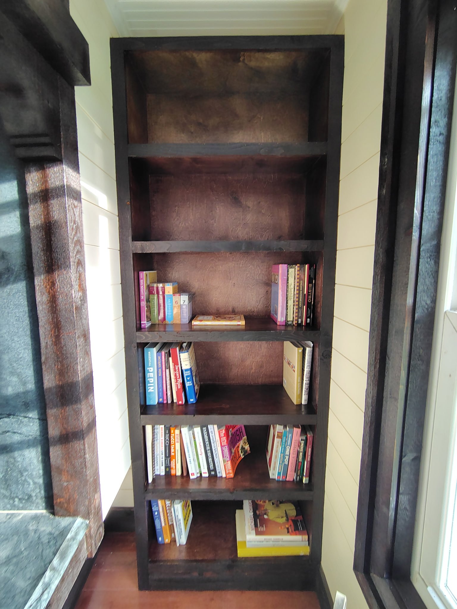 Completed dark stained built-in bookshelf with books in Pierson Florida home.