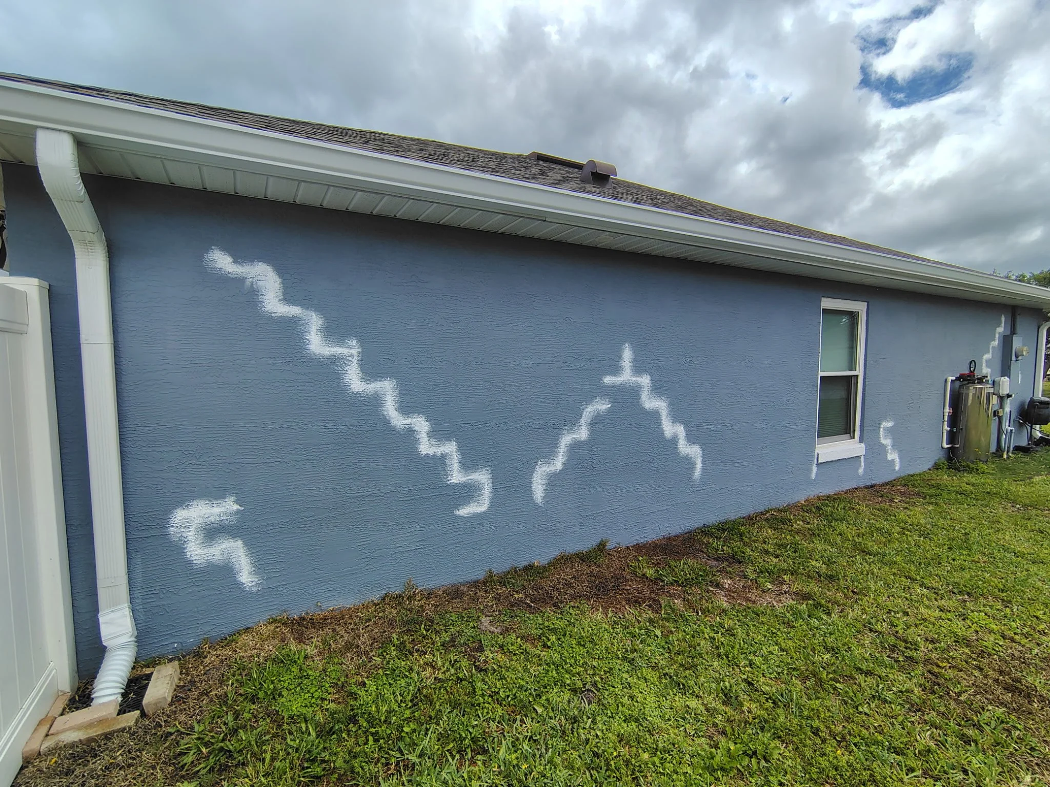 Stucco wall repair before exterior painting in Deltona FL showing patched cracks and prep work