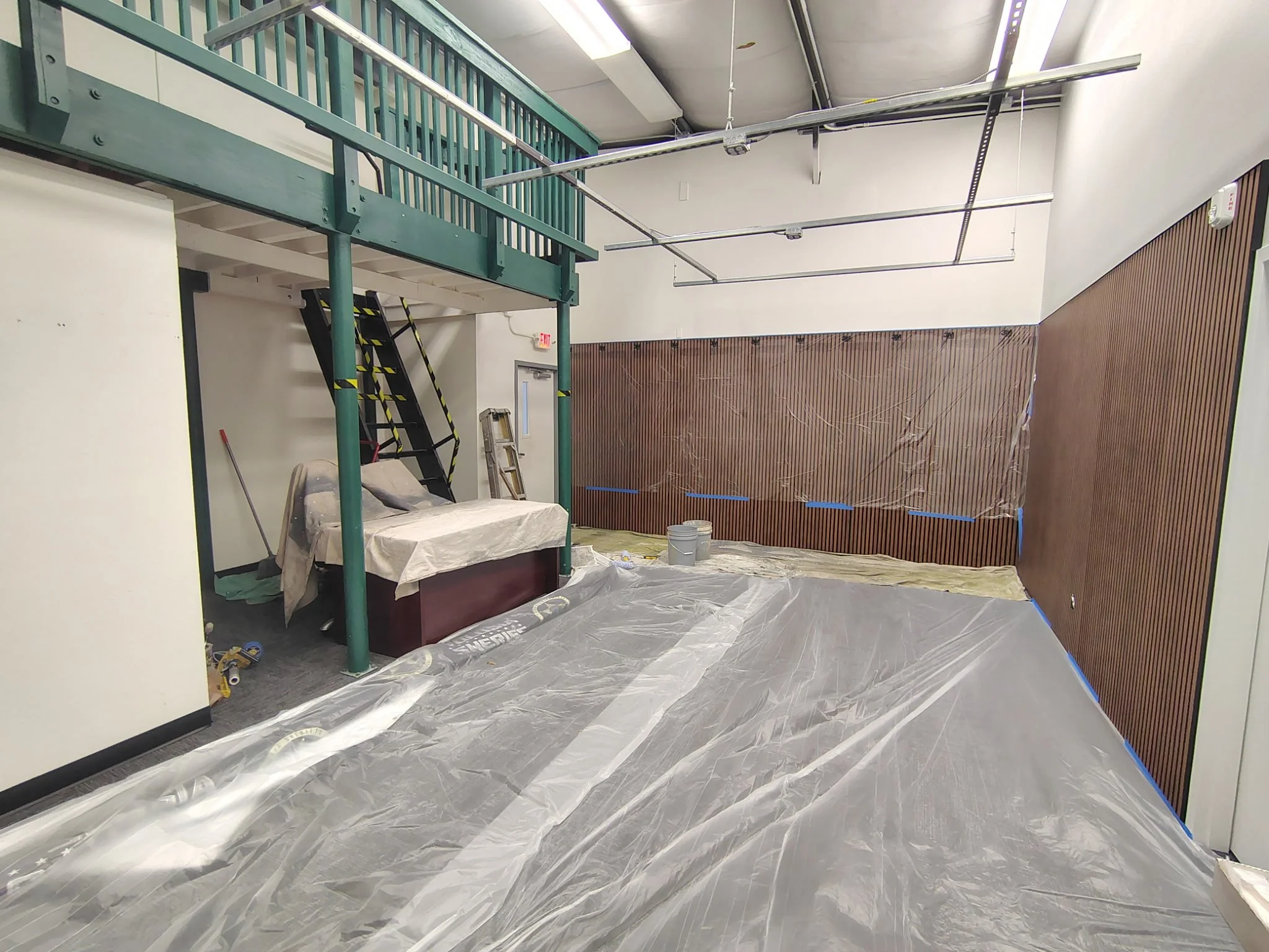 Volusia County business interior painting project with protected flooring, taped wood wall, and commercial painting preparation.