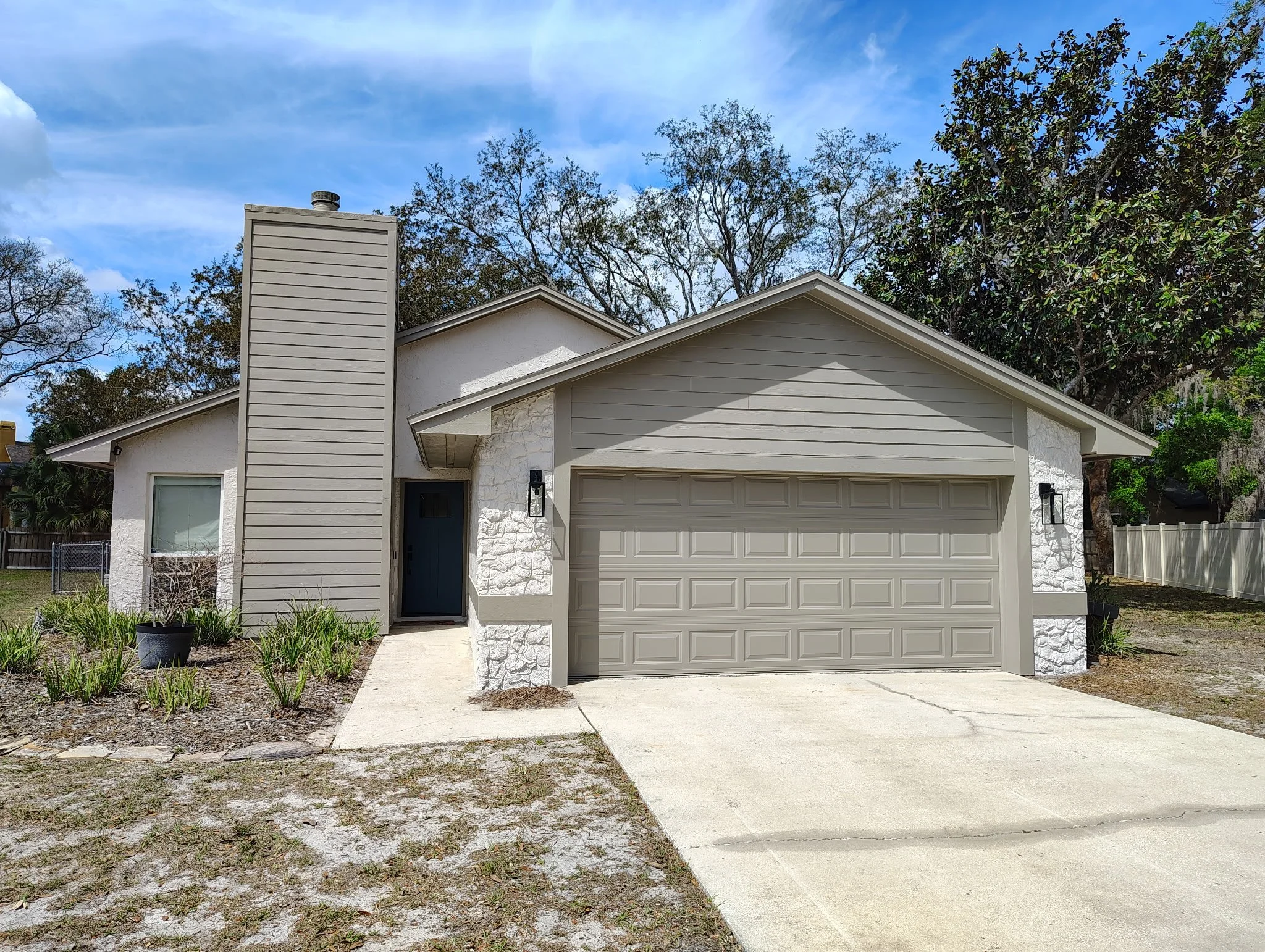 after exterior painting Winter Park FL modern white house gray garage door taupe trim
