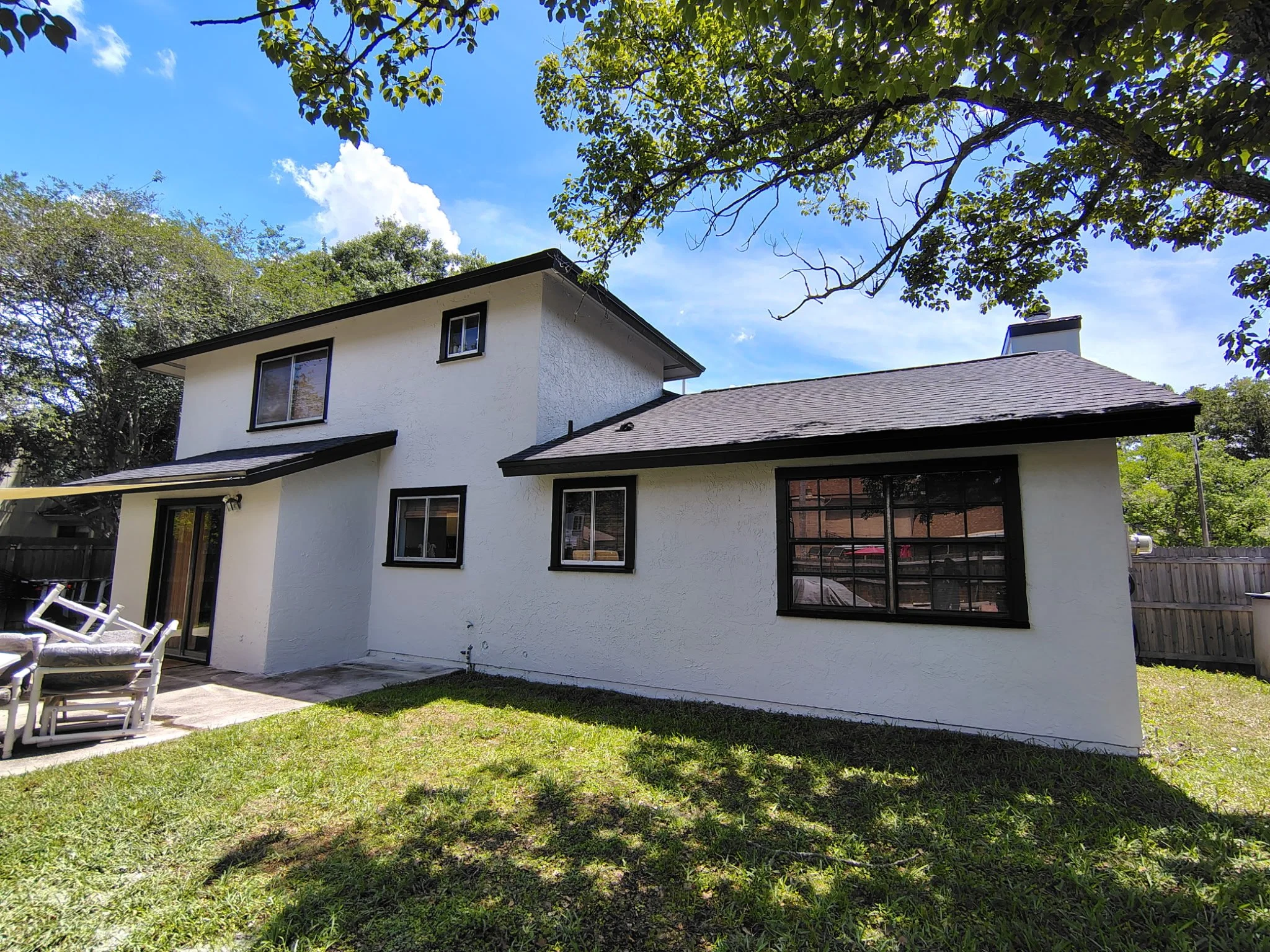 Backyard view of Longwood FL home after exterior painting with neutral body color and black trim.