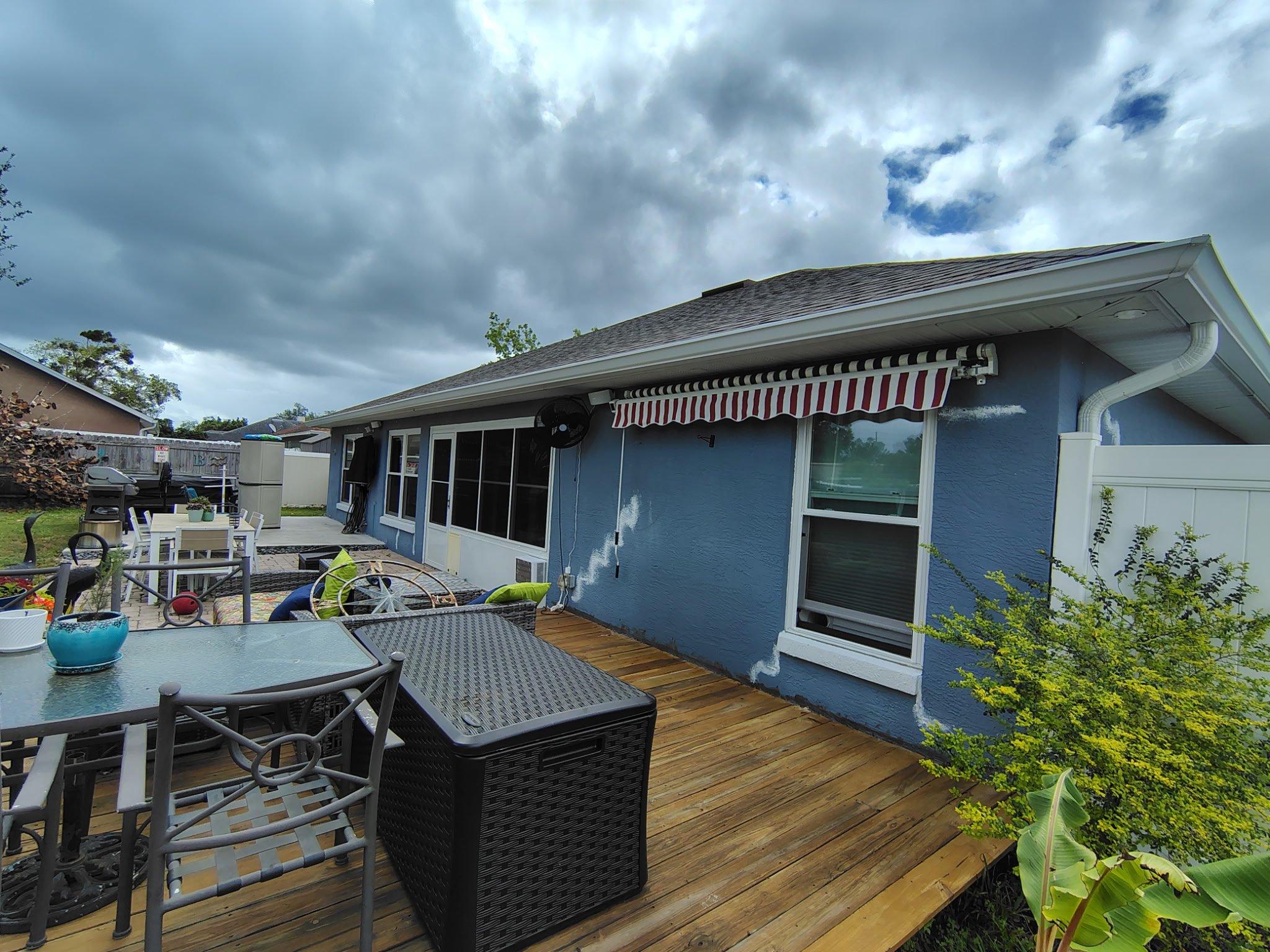 Deltona home exterior before painting deck side view with stucco wear and fading paint