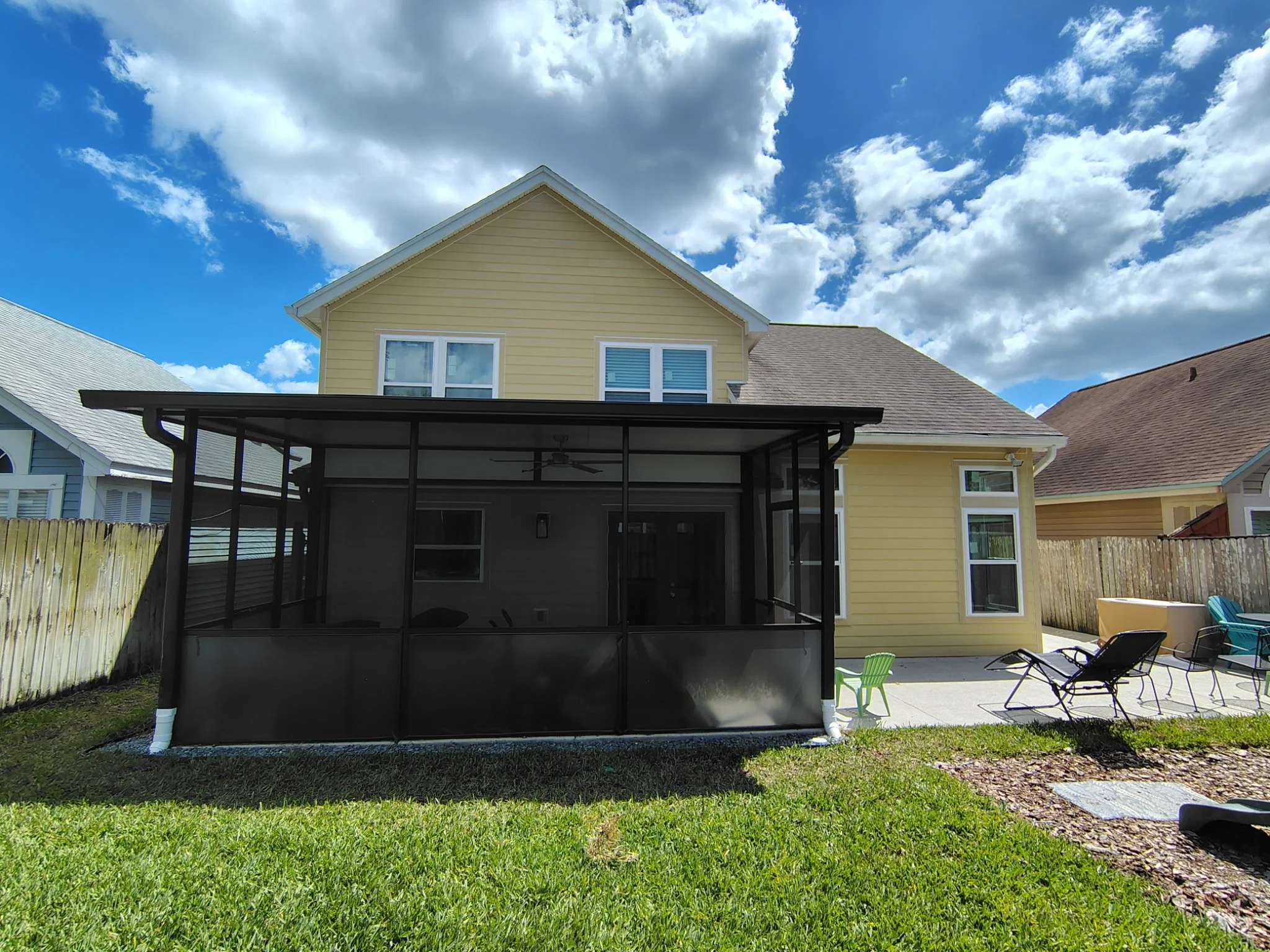Backyard view of Longwood FL home before exterior painting with screened enclosure