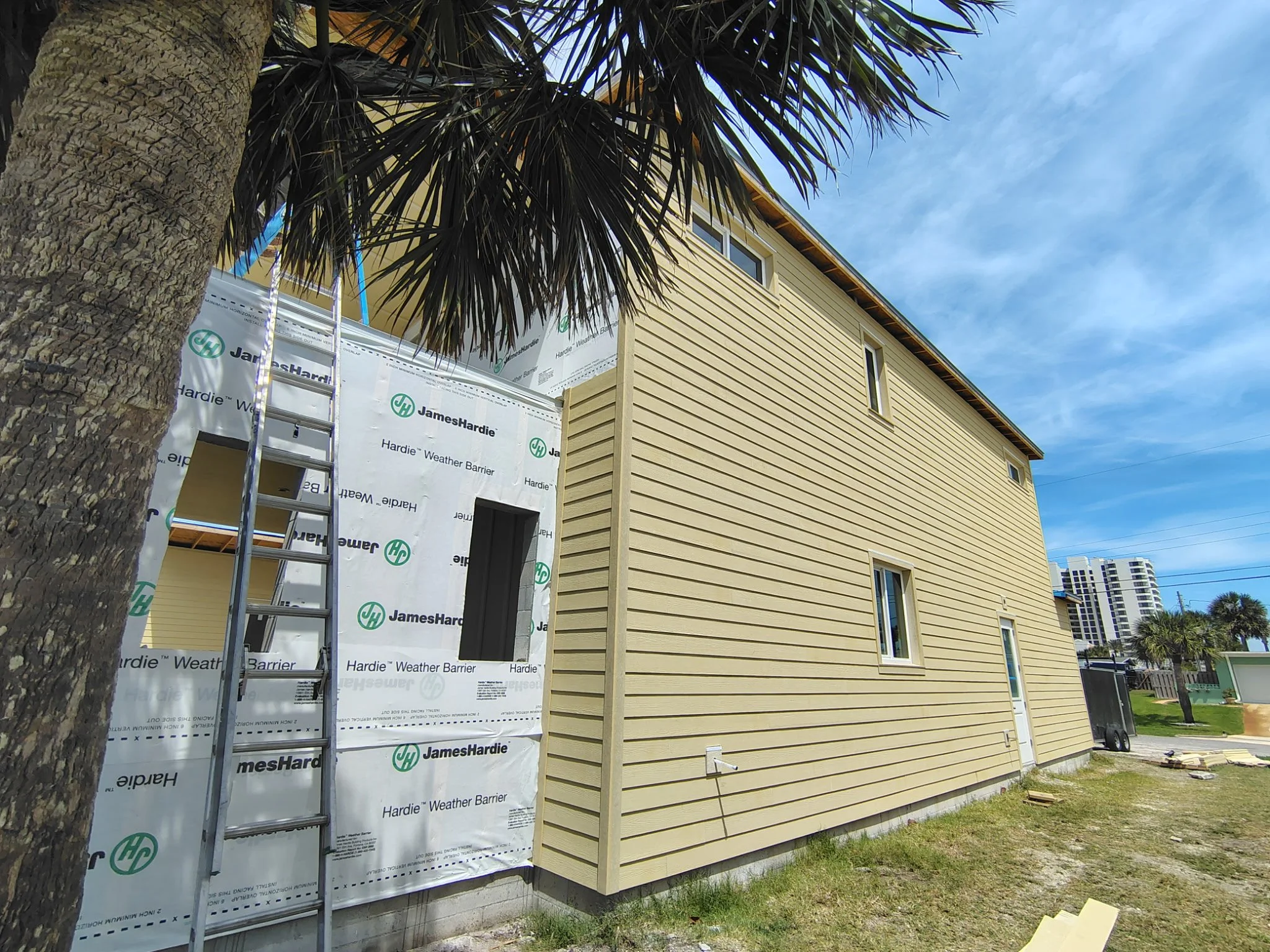 Hardie board siding installation and ladder setup during exterior painting prep in South Daytona