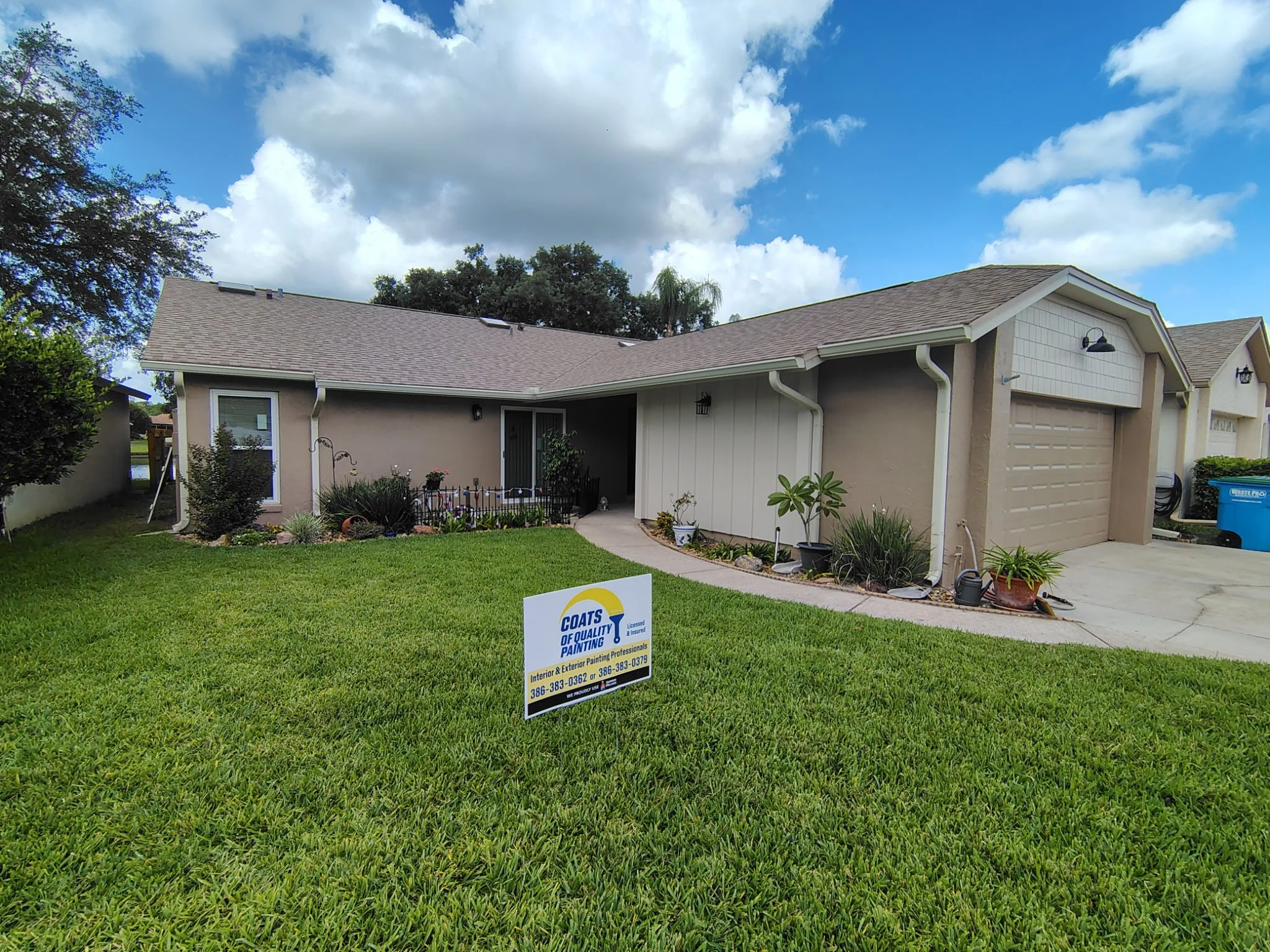 Completed Winter Springs exterior painting project with modern neutral paint, fresh curb appeal, and Coats of Quality Painting yard sign.
