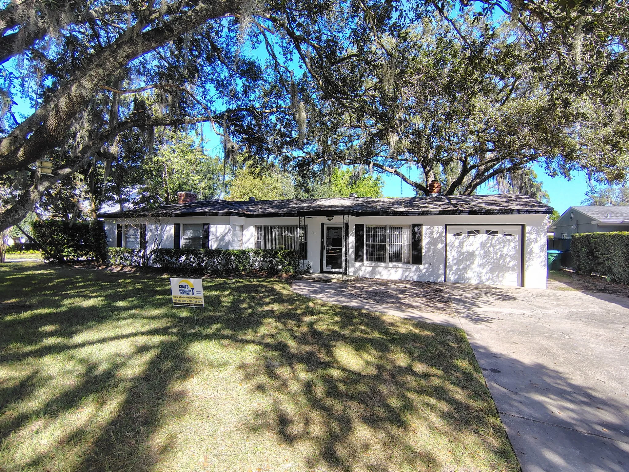 Coats of Quality Painting yard sign in front of a refreshed white-and-black Winter Park Florida home.