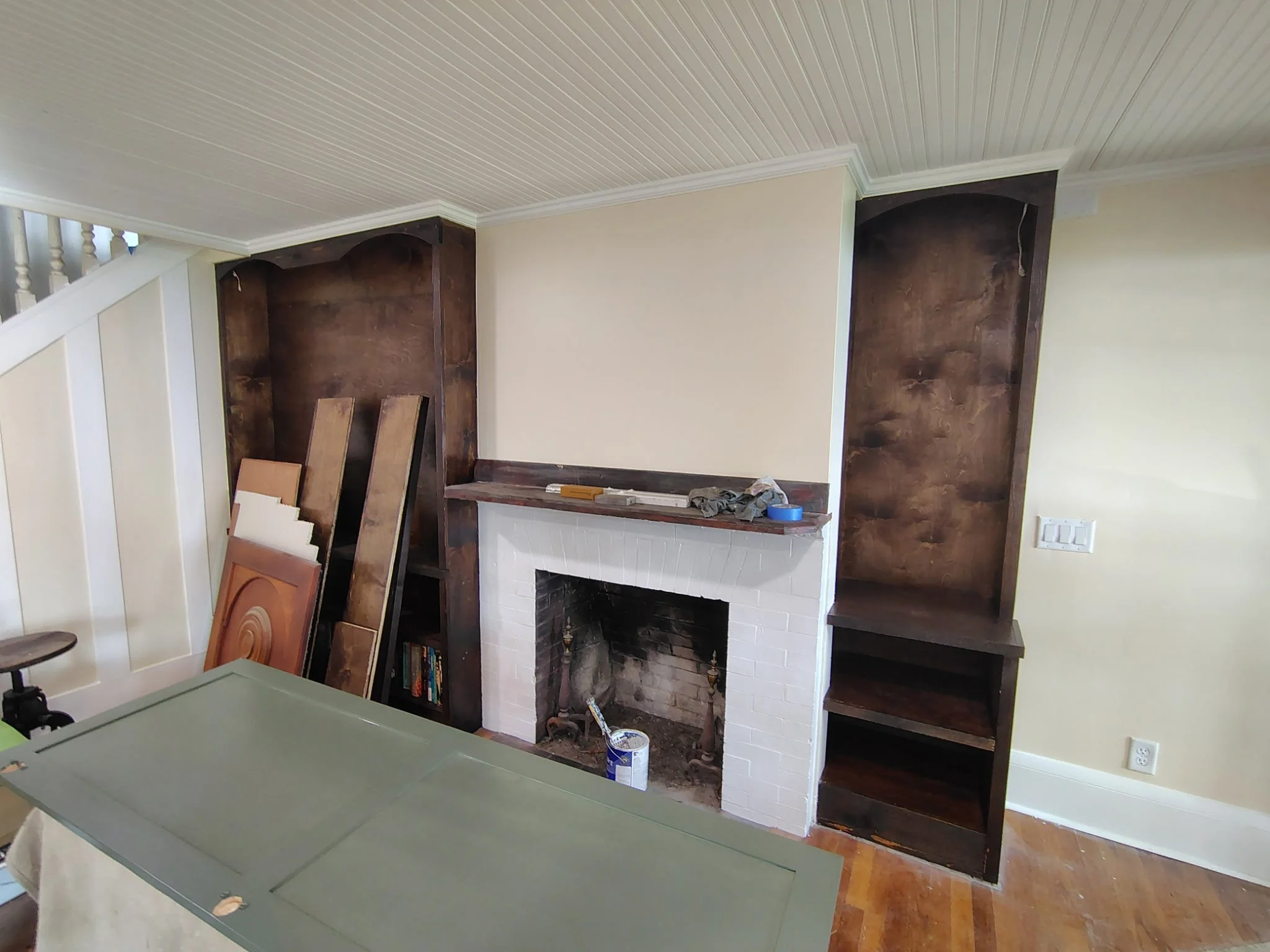 Wood stained built-ins around a fireplace with cabinet painting in progress in Pierson Florida.