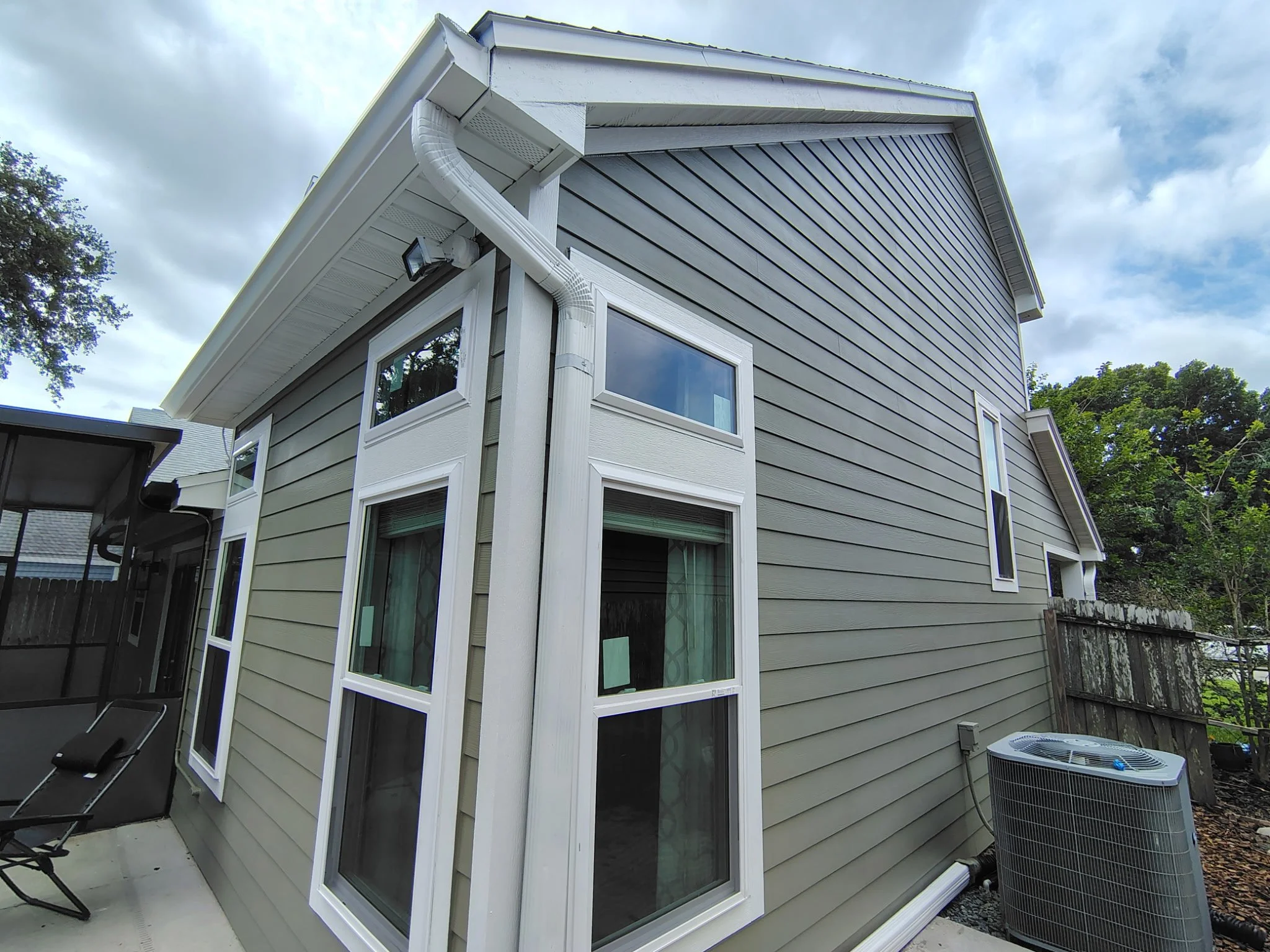 Exterior window trim painting Longwood FL white trim green siding