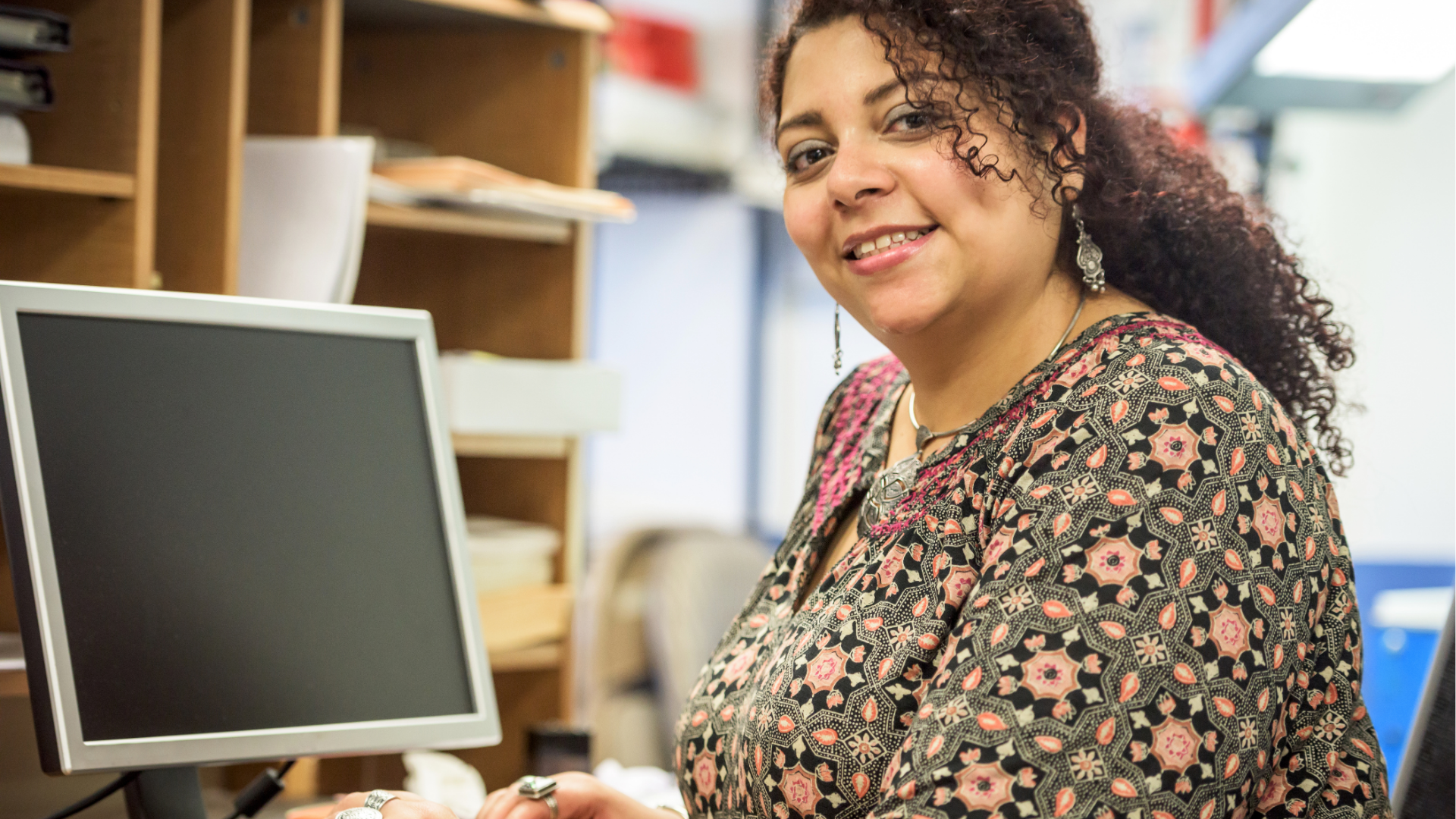 smiling school secretary working on her computer