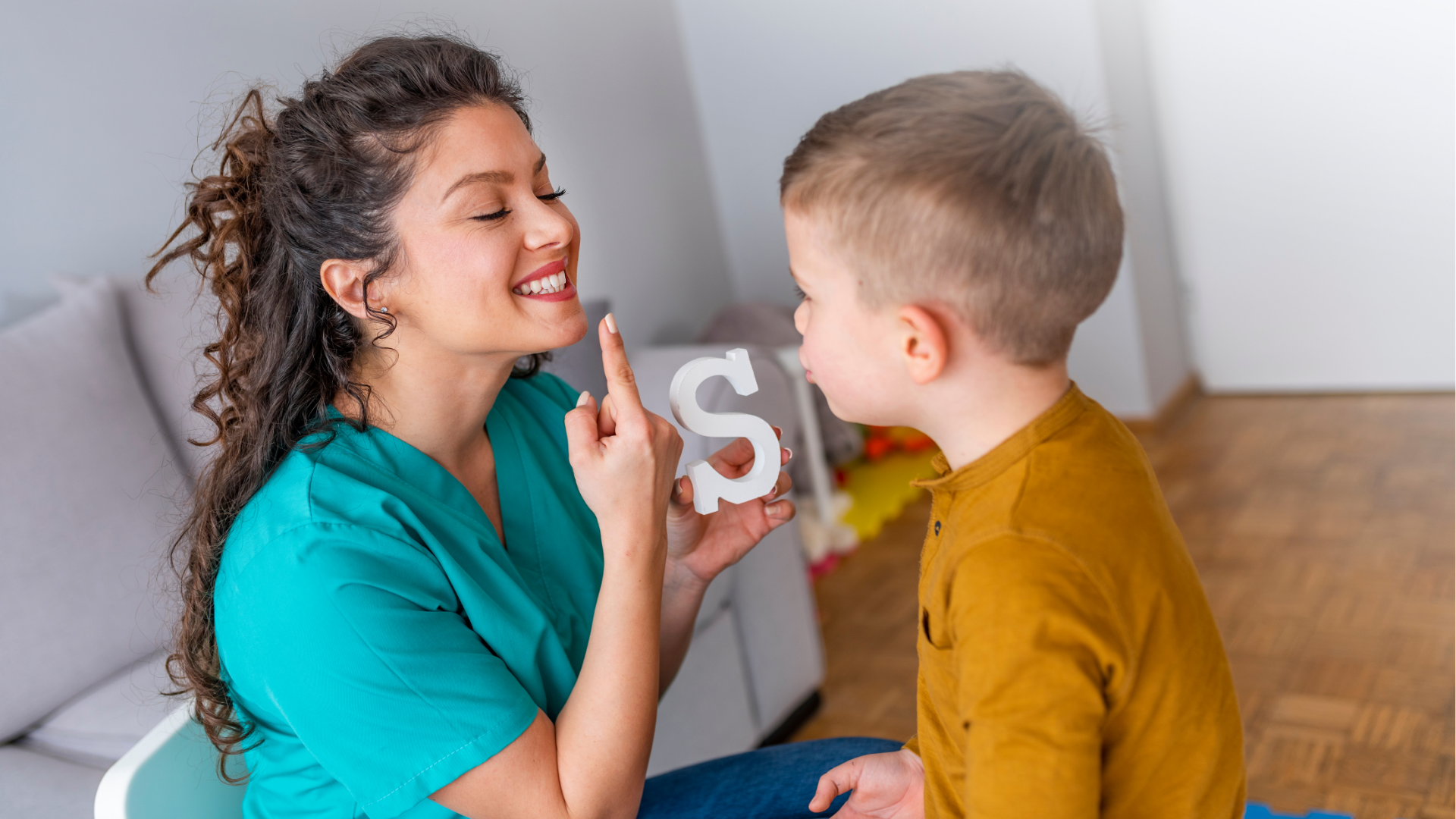 young female speech therapist working with a little boy