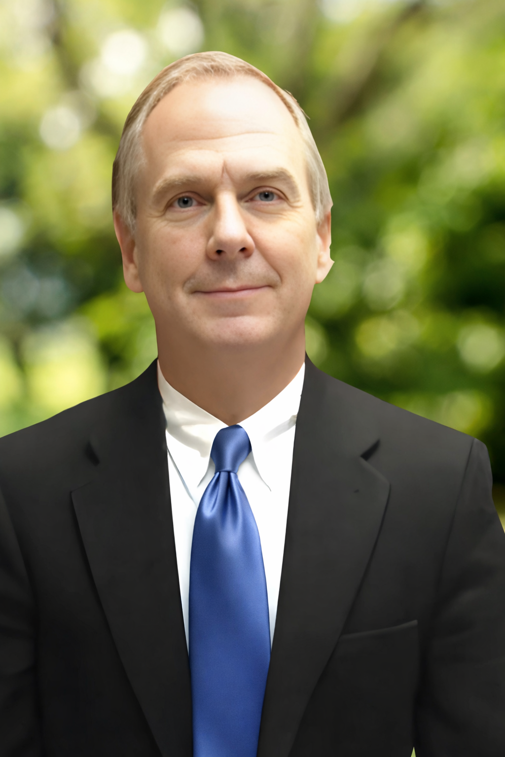 white male in early 60s with navy suit and blue tie
