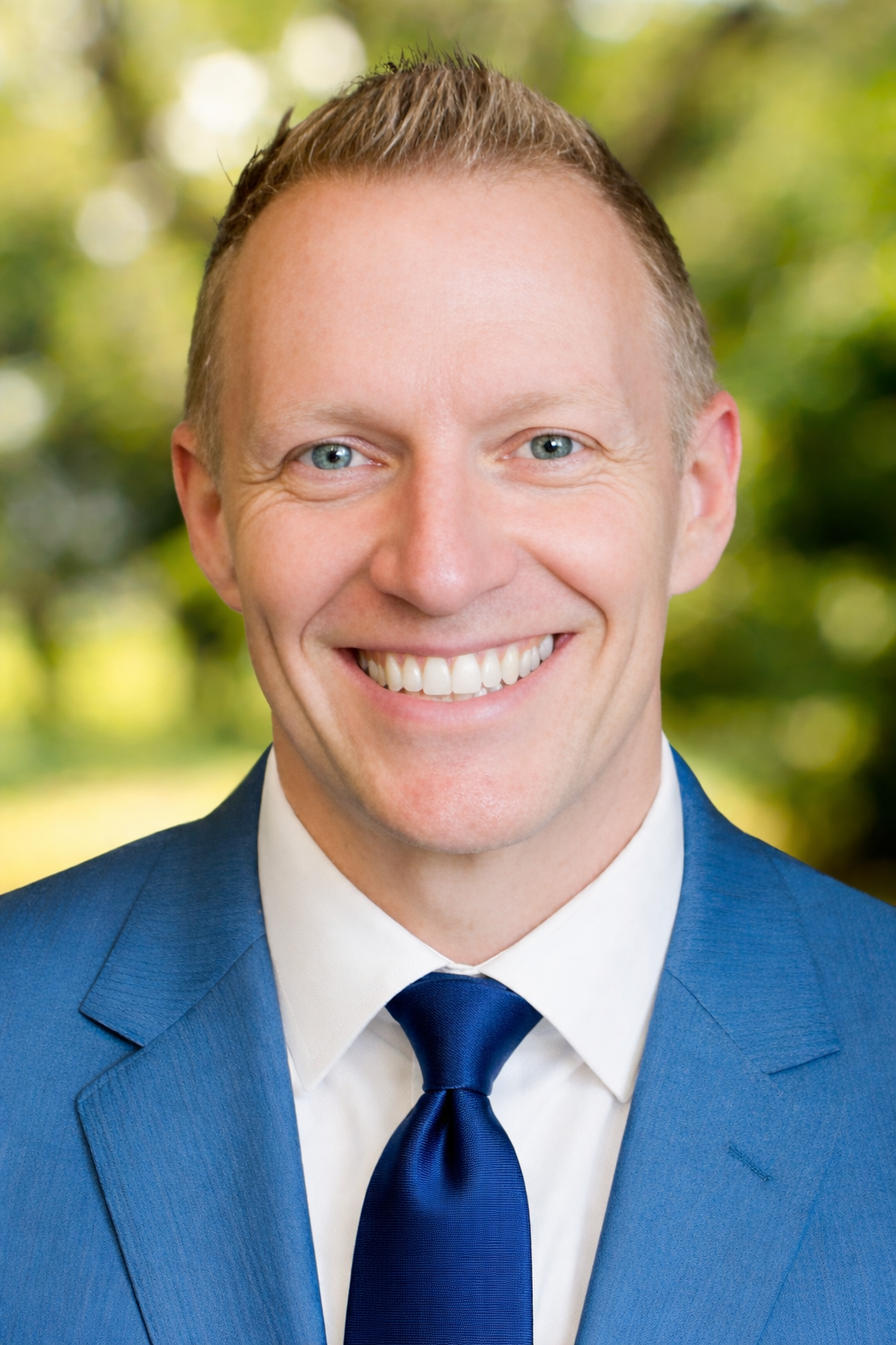 smiling middle age white male in a blue suit and tie