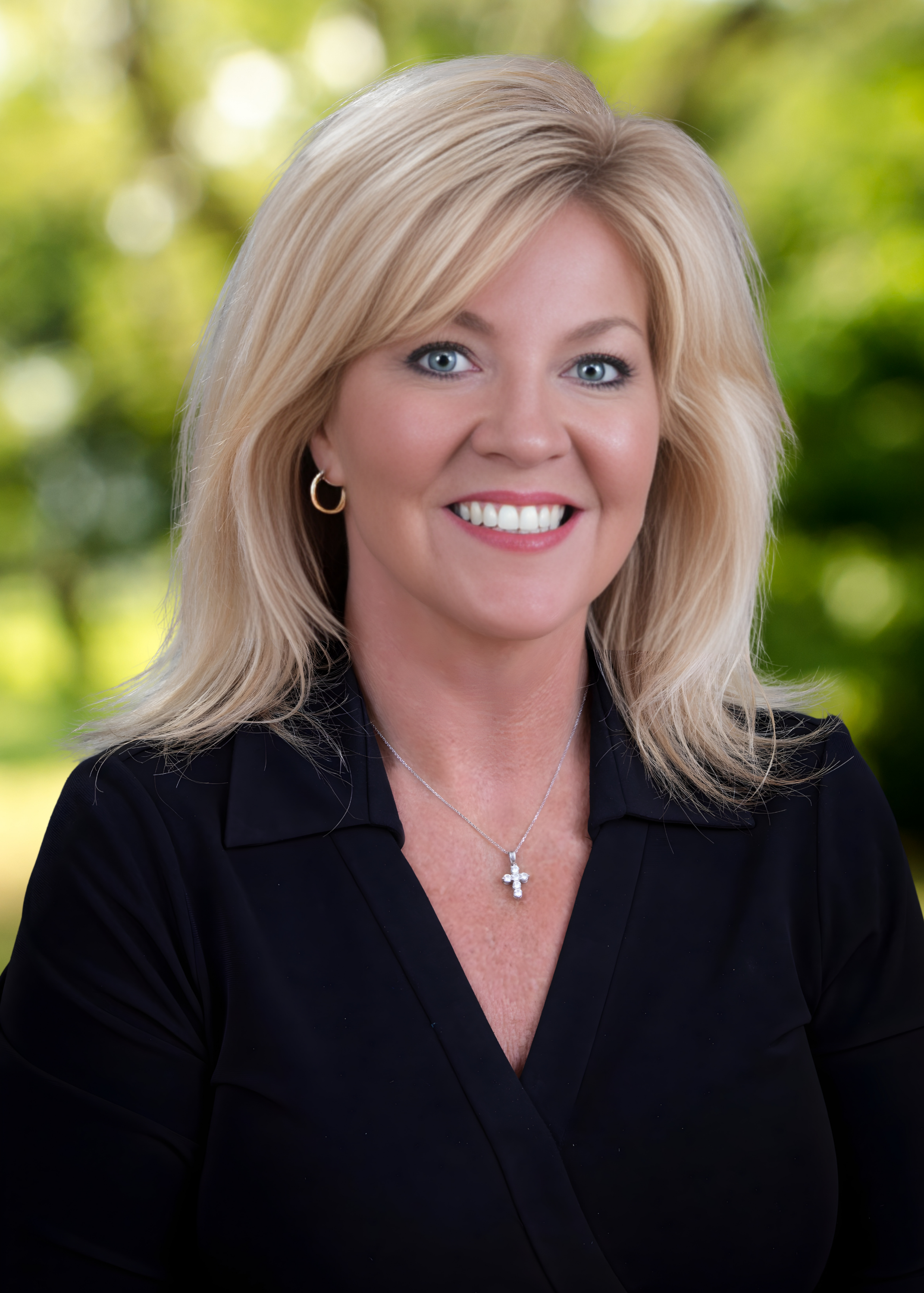 smiling female executive in black suit with blond hair