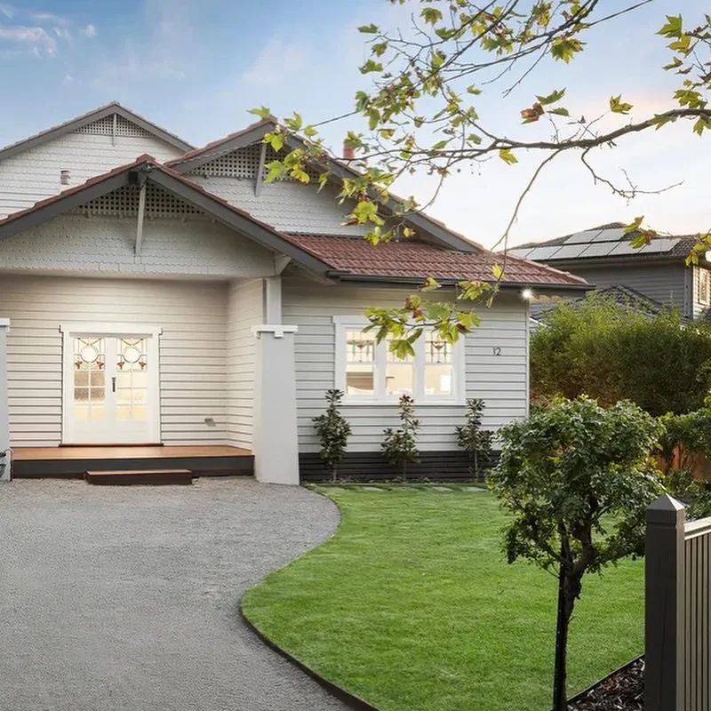 Front yard landscaping with lawn and gravel driveway