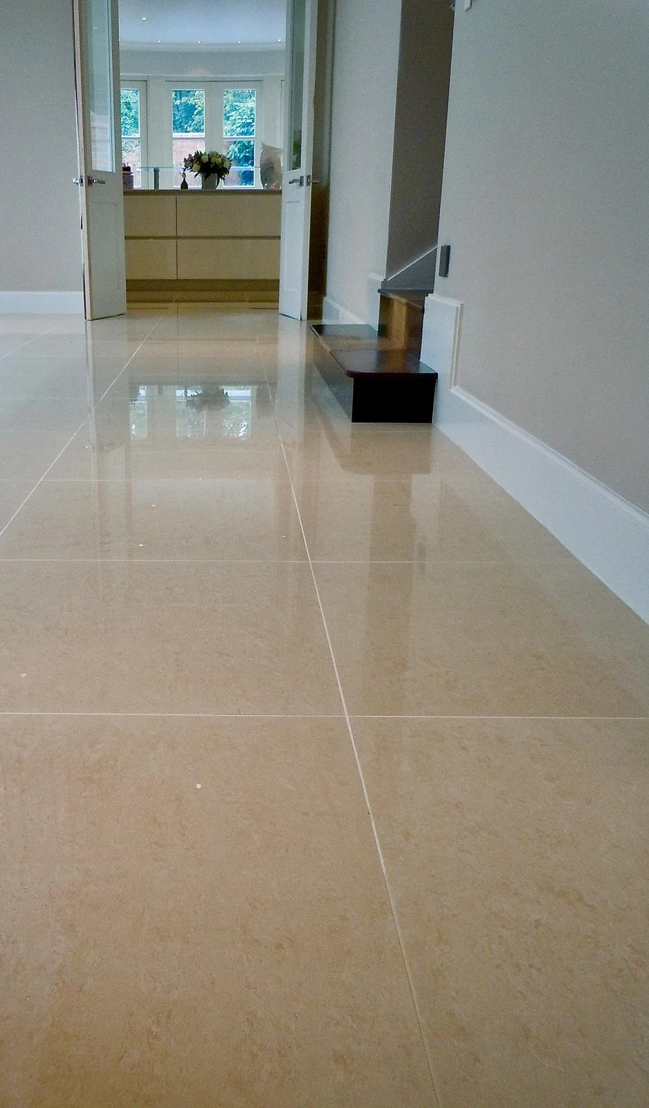 Beige porcelain-tiled floor deep-cleaned and polished.