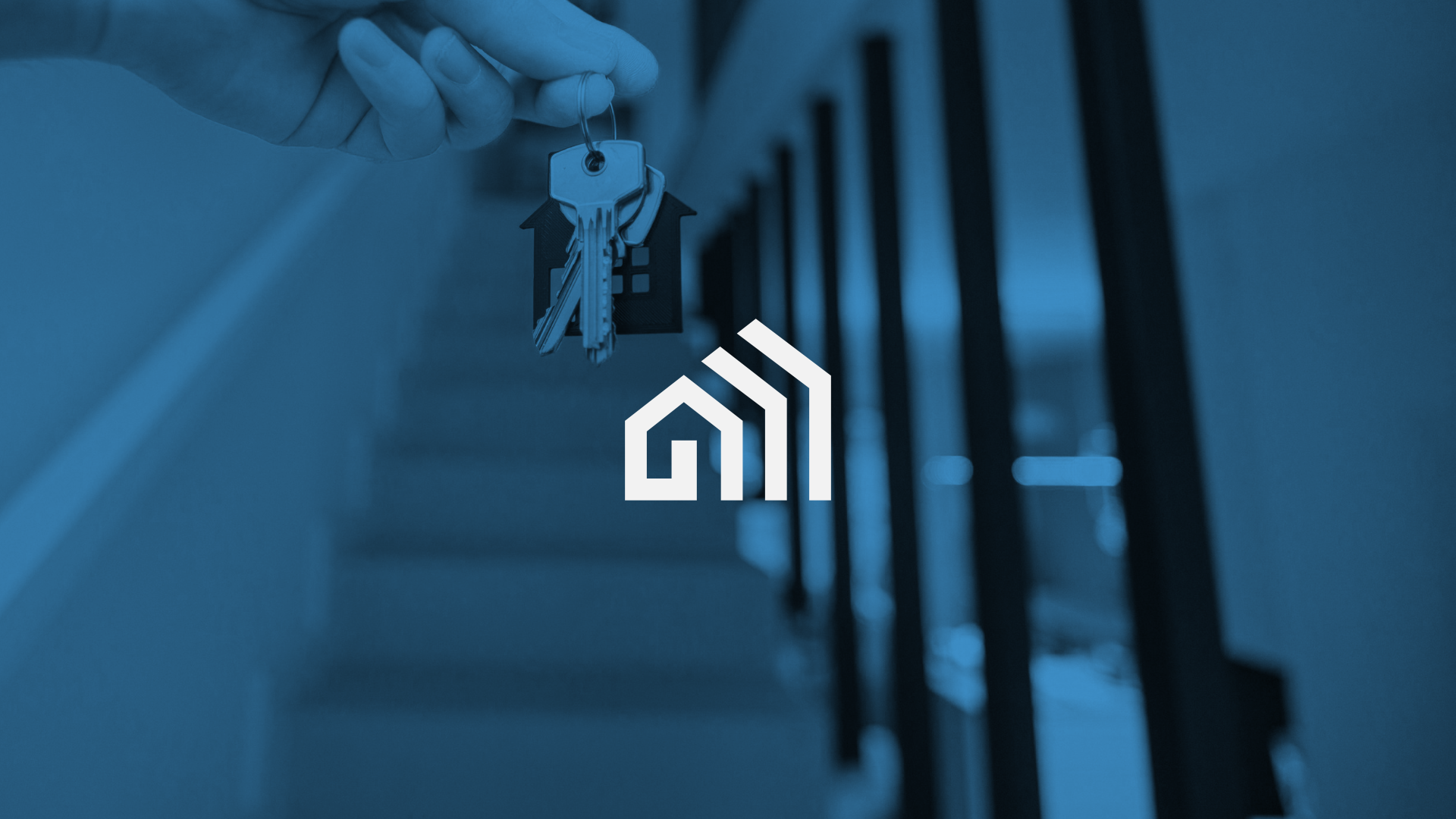 A person holding a keyring with house-shaped keychains in front of a staircase railing, with a logo of a house with rising bars overlayed.