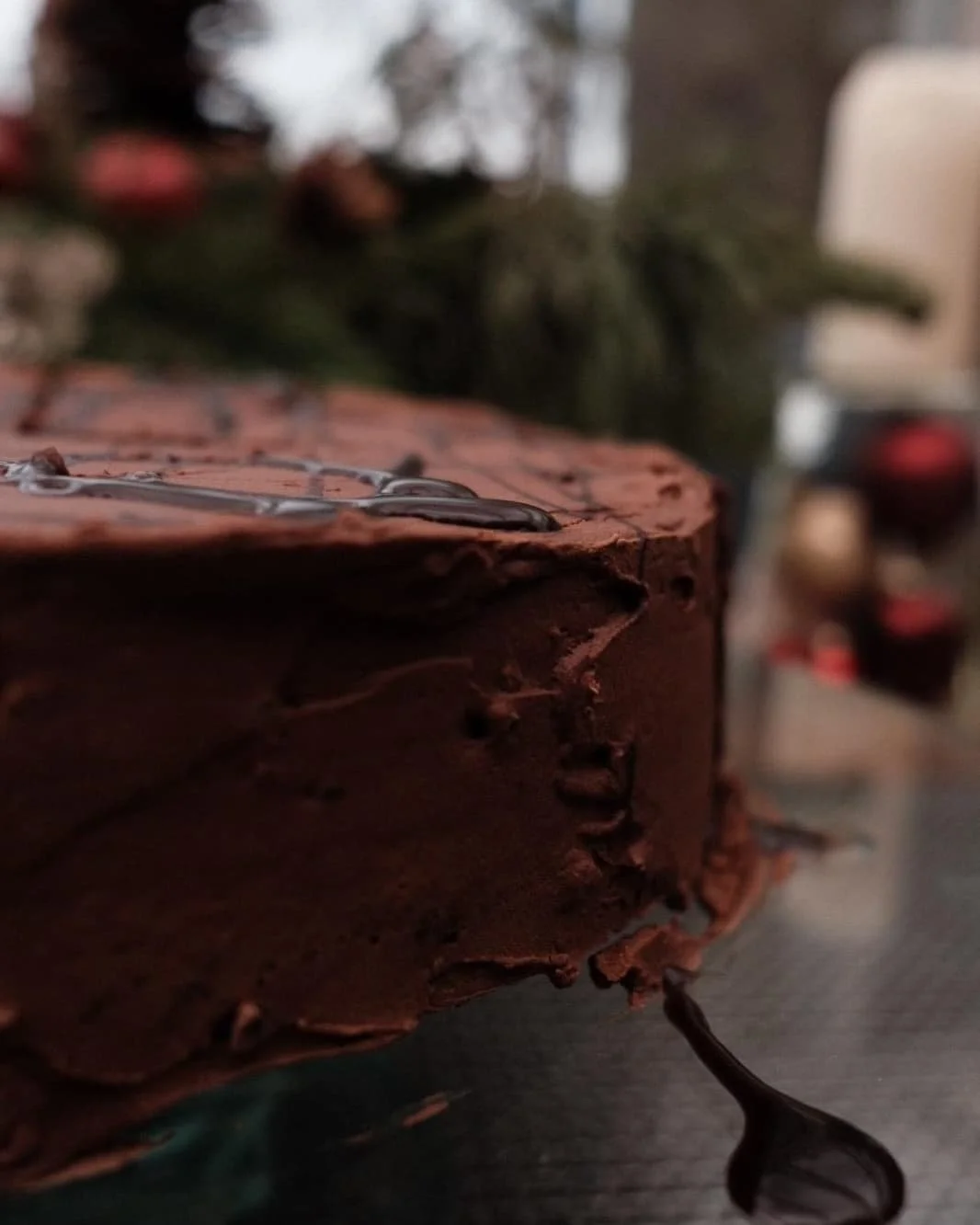 Nahaufnahme einer Schokoladentorte mit Schokoladenglasur auf einem Teller.