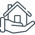 A hand holding a house model with a roof and chimney.