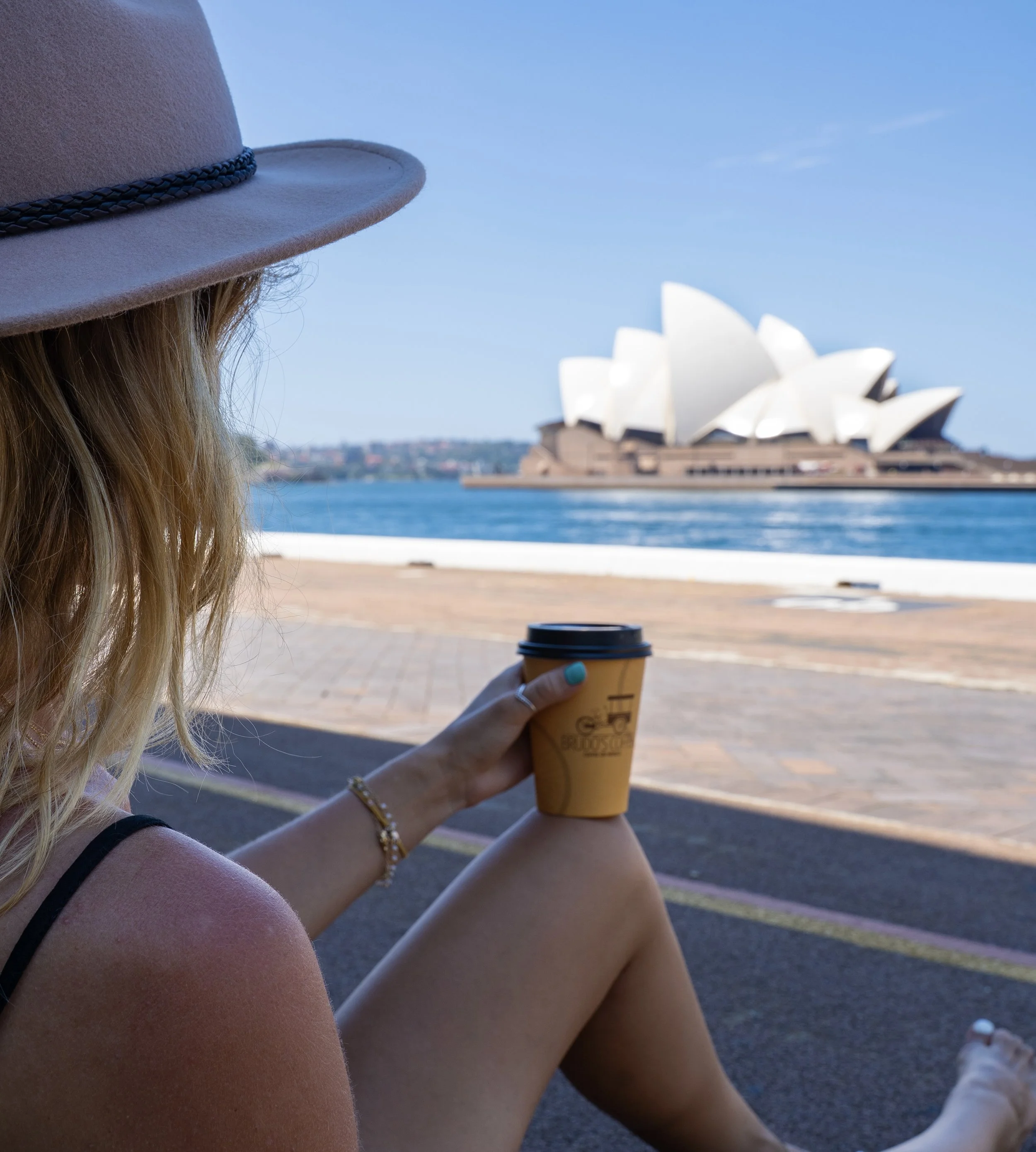 Kobieta-z-kubkiem-kawy-w-reku-oglada-opere-w-sydney-ebook-o-australii