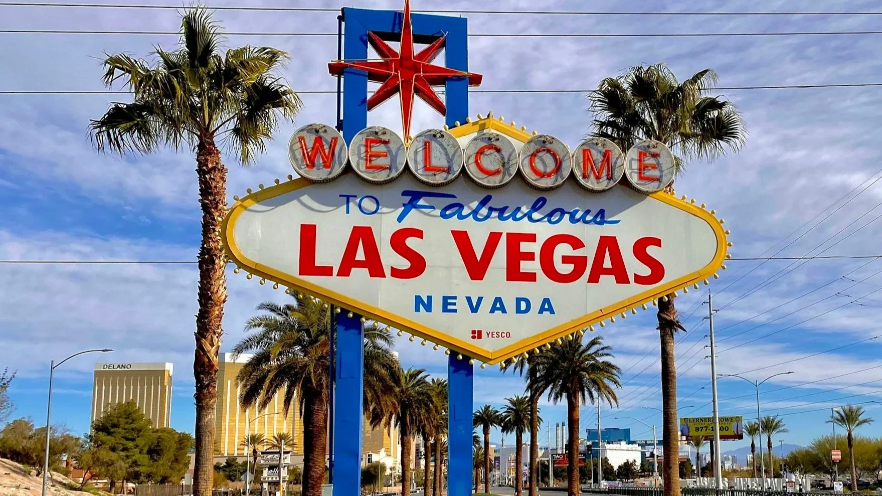 The Welcome to Fabulous Las Vegas sign with palm trees and a blue sky in the background.
