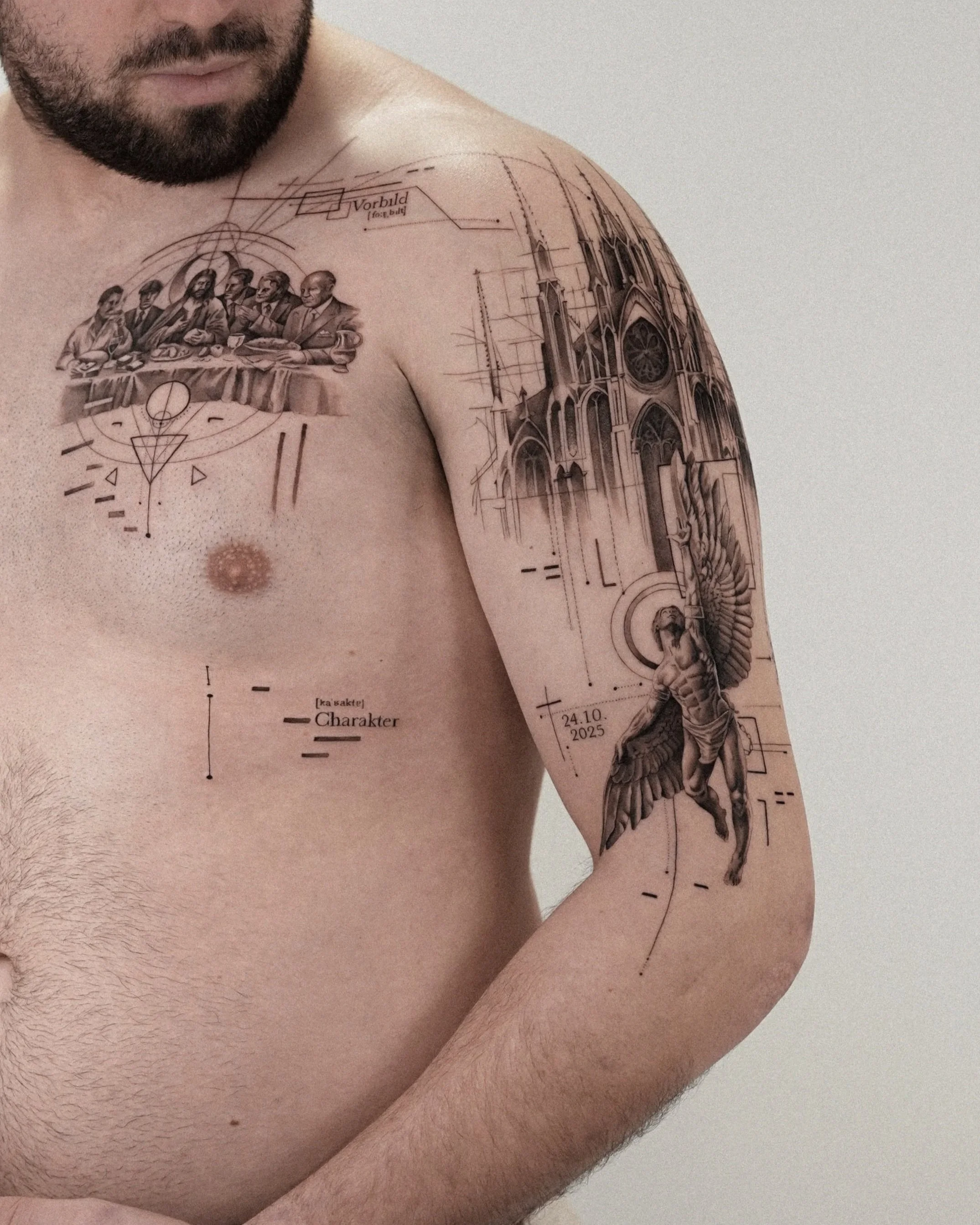 Tattoo on a man's shoulder and upper arm depicting a scene of four men at a table, a gothic church, and scientific diagrams, with some text labels.