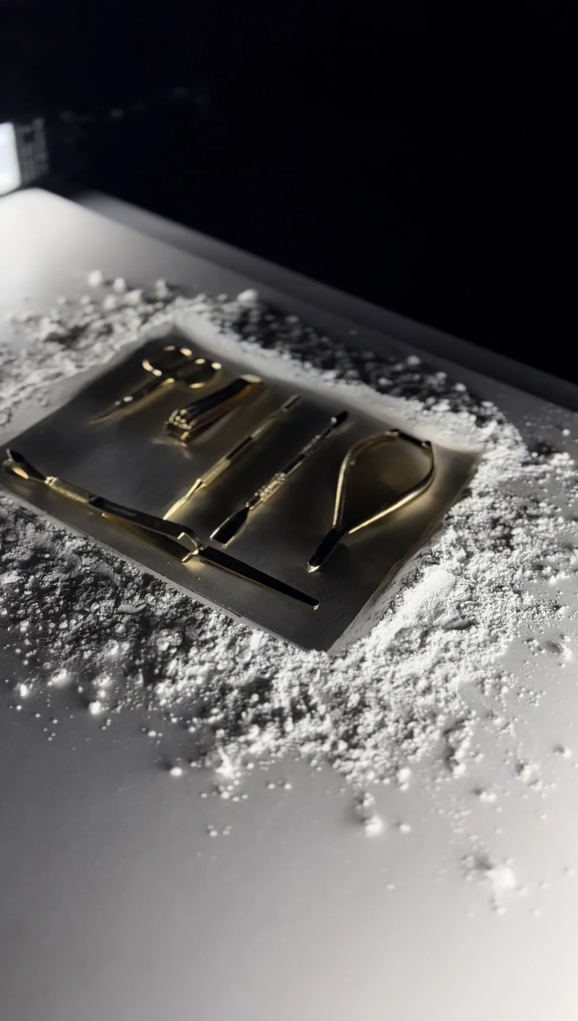 nail tools, laid on a metal tray on a snow-covered surface photography shot