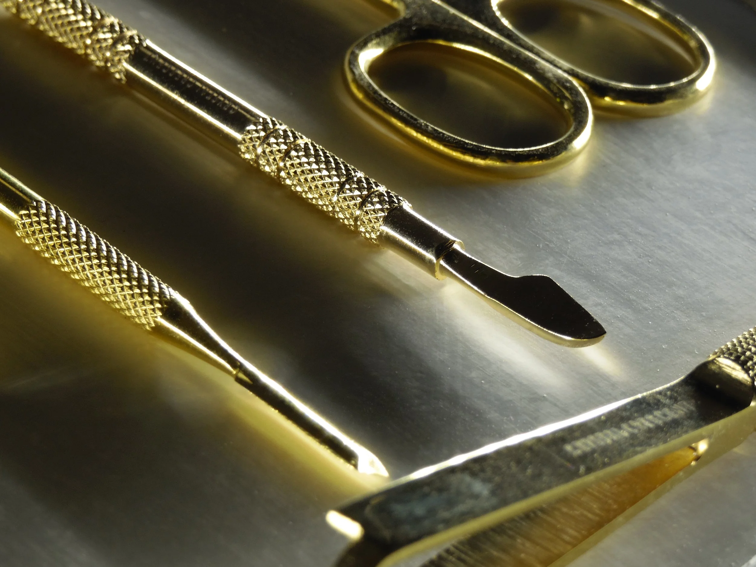 Close-up of nail tools, on a metal surface.