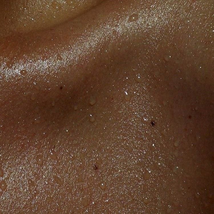 Close-up of human skin with water droplets.