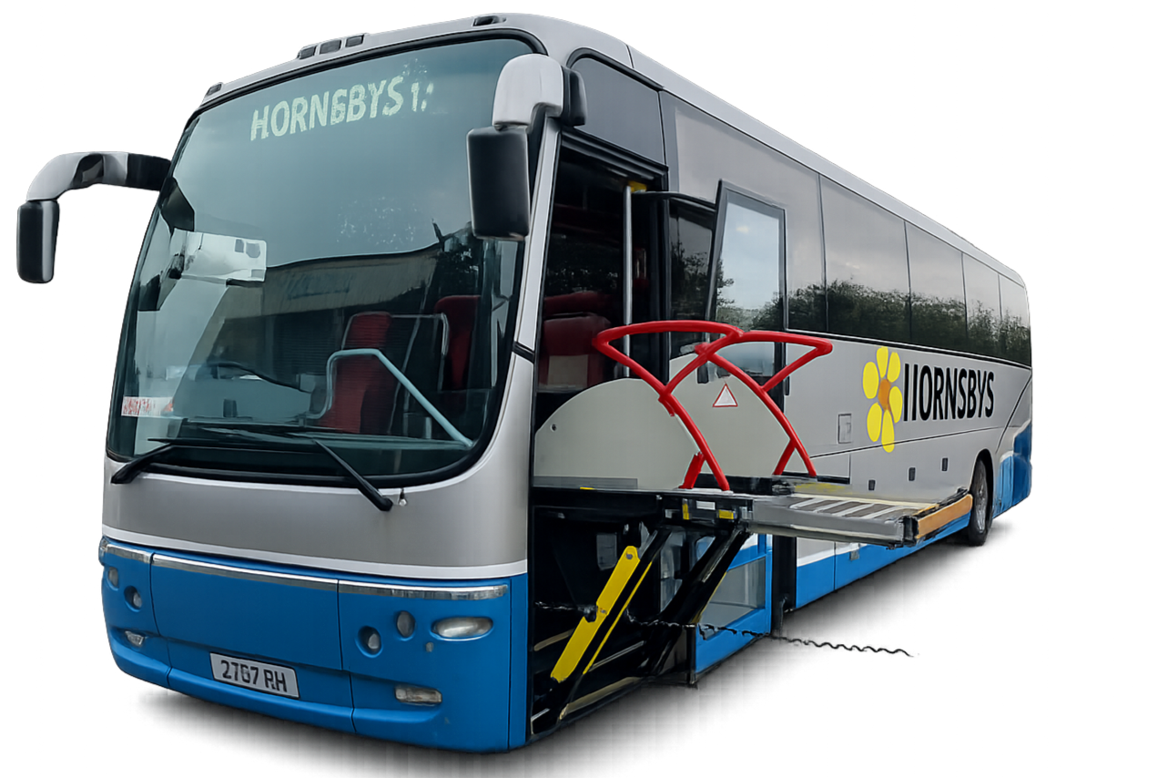 A white and blue bus with the word Hornsbys on the windshield and Iornsbys on the side, equipped with a wheelchair lift extended from the side.