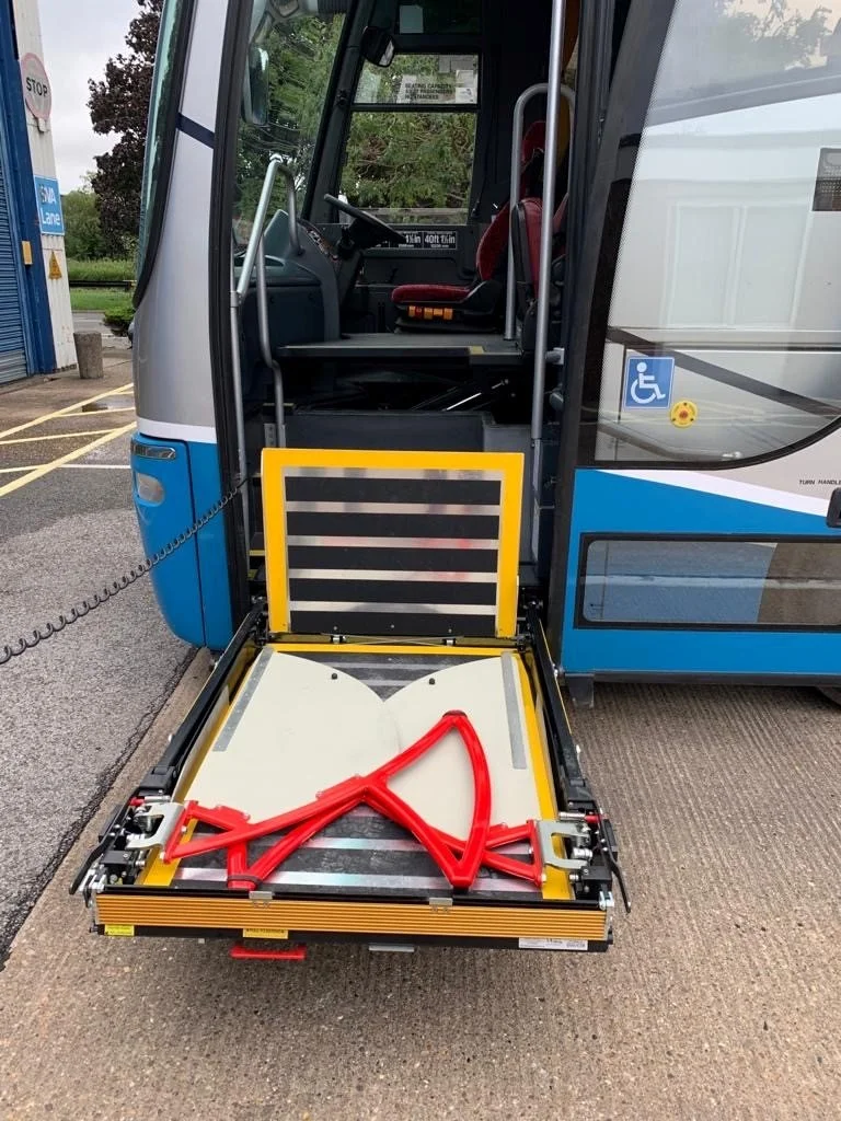 Double-decker black and gray Acklams coach bus parked in lot