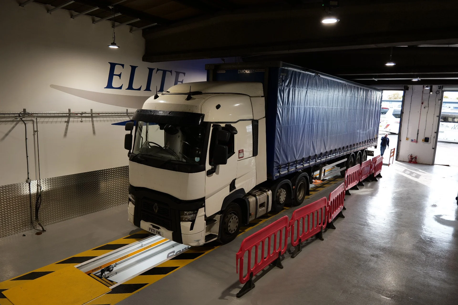 Black double-decker luxury passenger bus with 'ACKLAMS' logo on side, parked outside on a concrete lot.