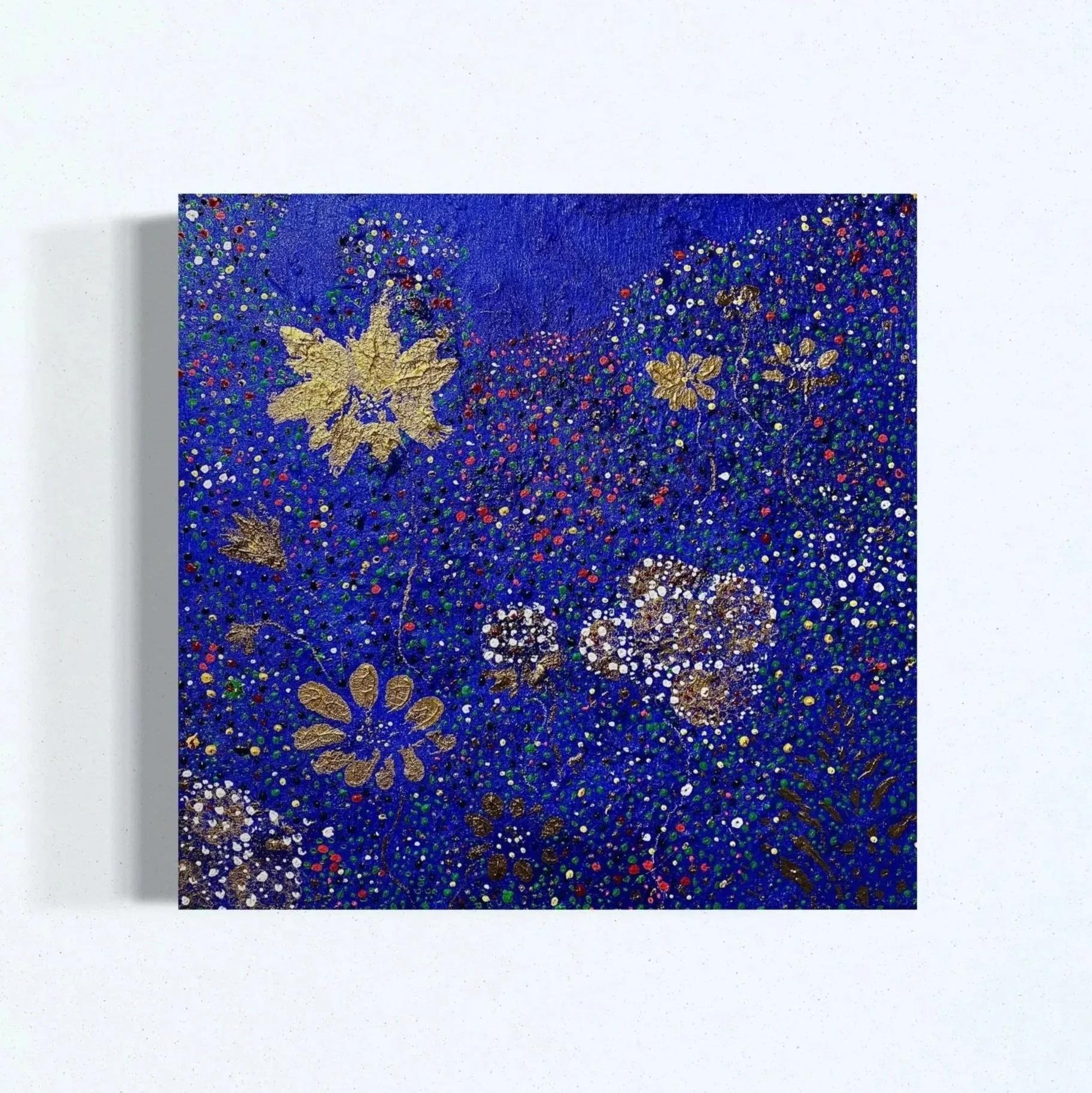 Artistic painting featuring a navy blue background with gold and white floral patterns, dots, and abstract shapes.