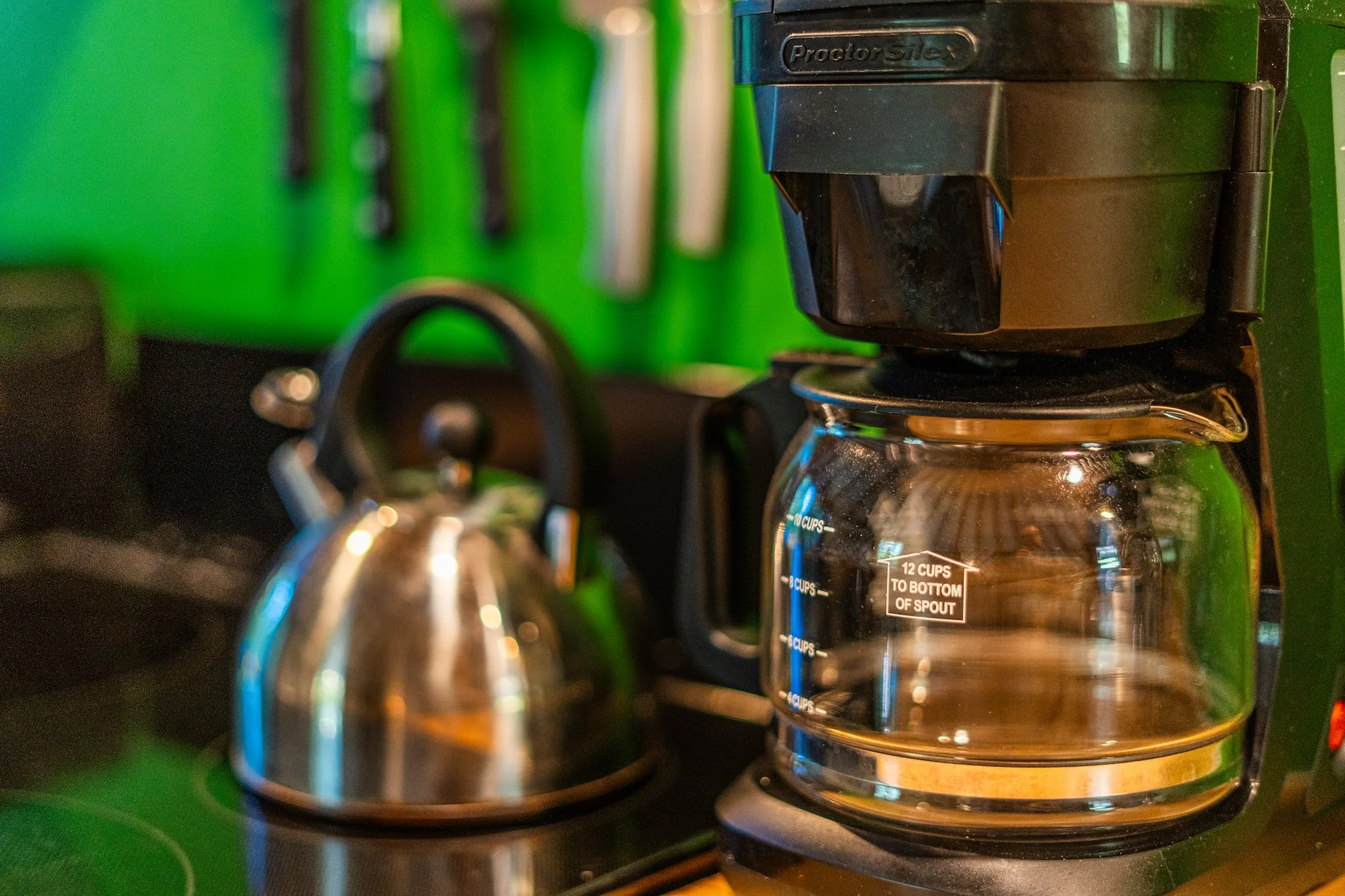 A coffee maker brewing coffee into a glass carafe on a kitchen counter in the cozy yurt at New River Nooks in Fayetteville WV.