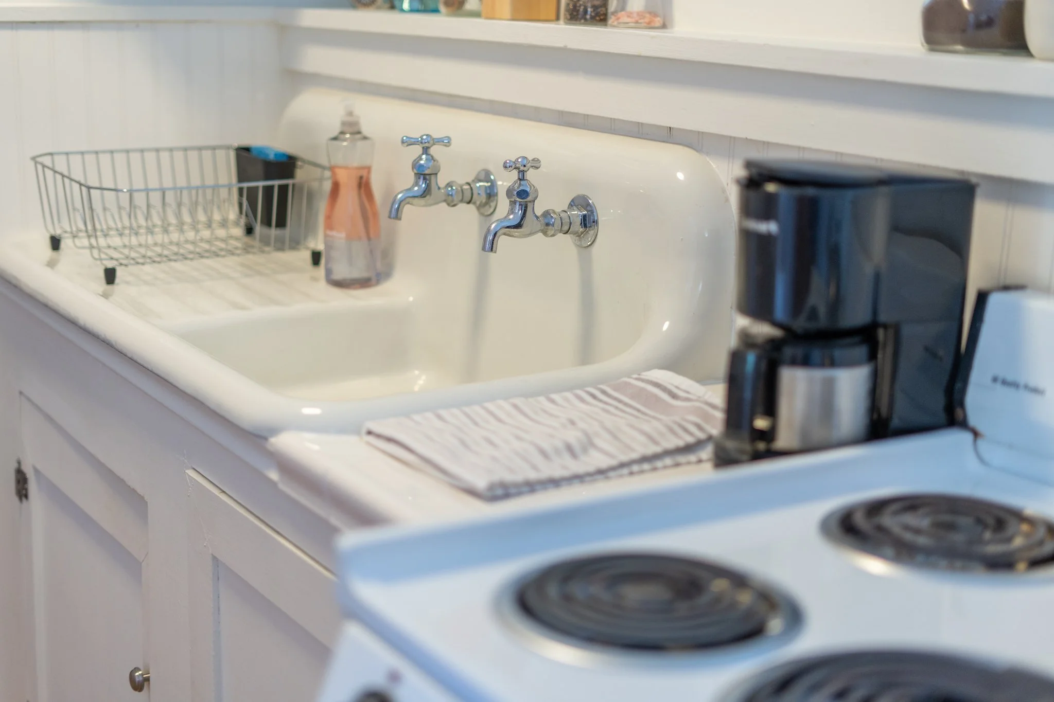 Close-up of kitchenette with sink, stove, and coffee maker in Cloud 9 Loft Apartment at New River Nooks in New River Gorge, WV